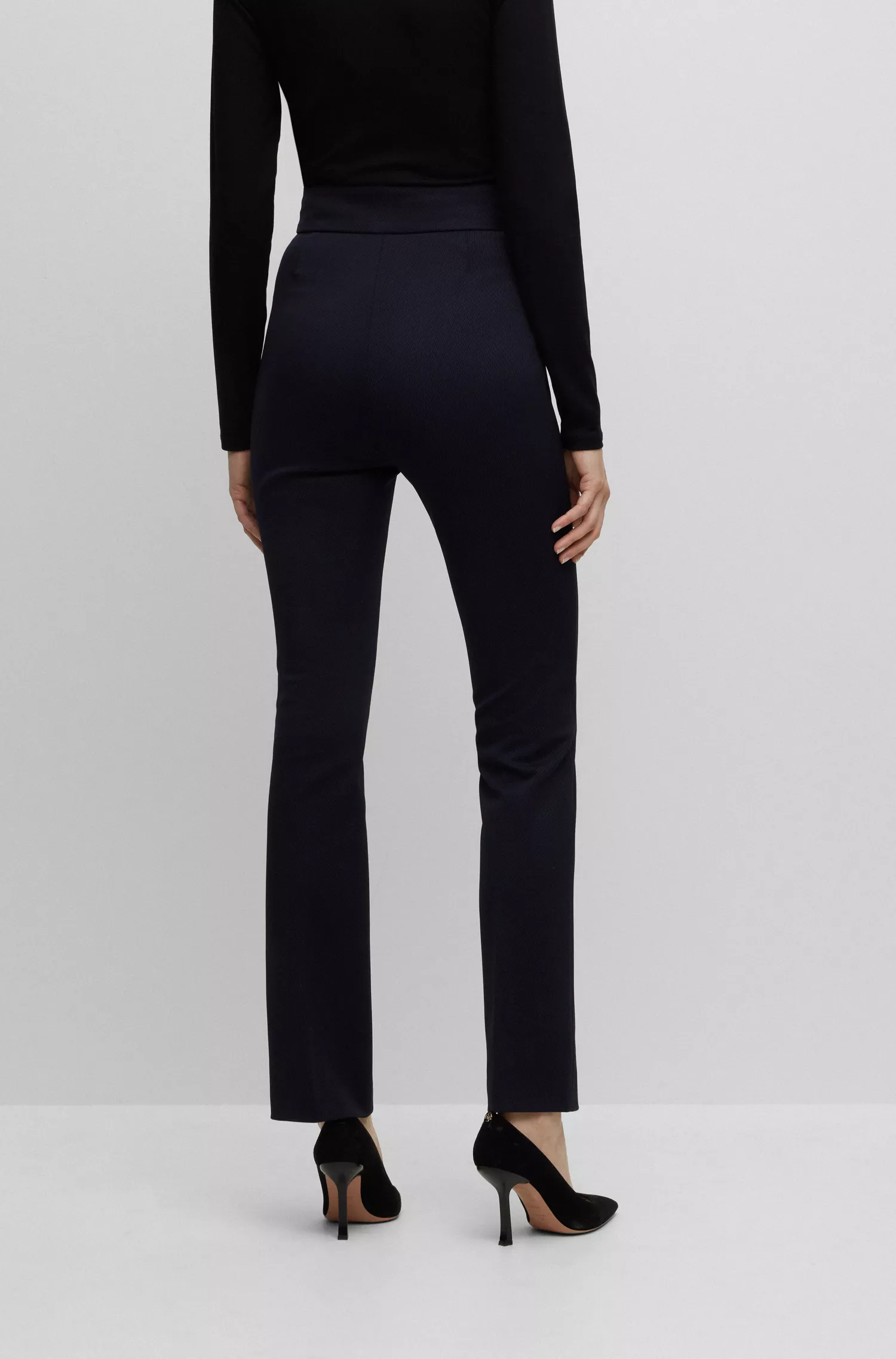 Calça BOSS preta, corte slim, cintura alta e pernas flare.