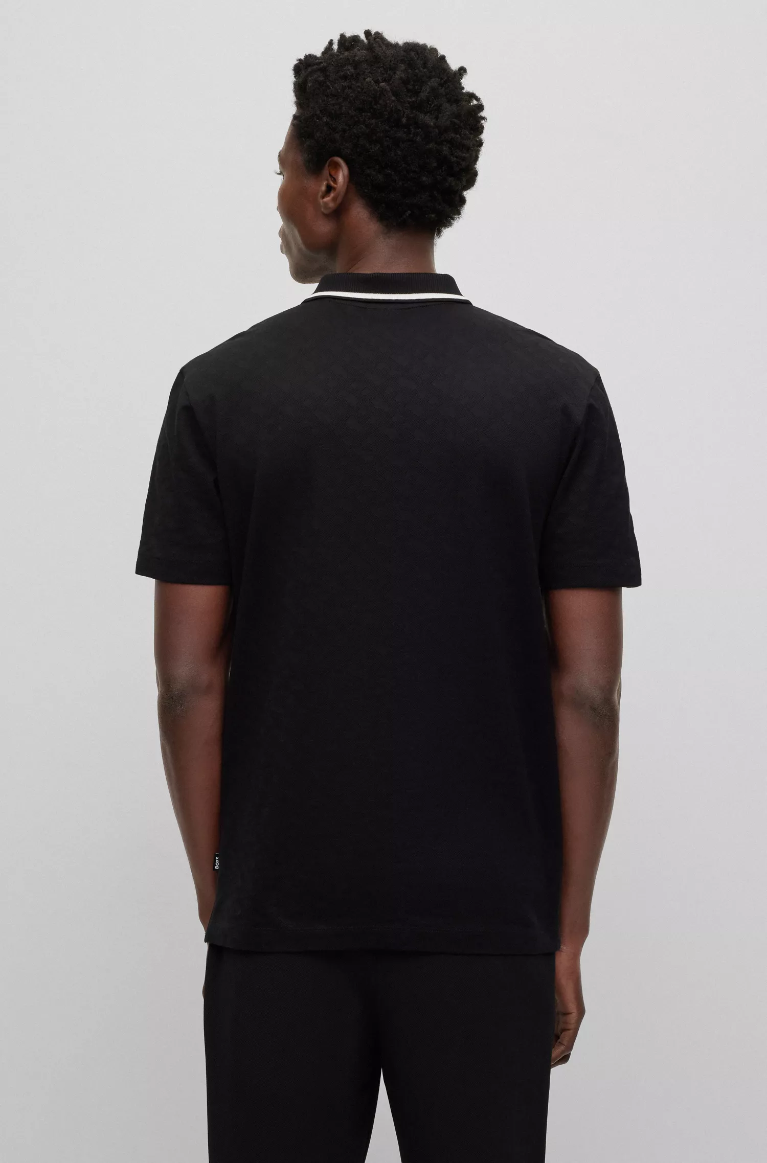 Camisa polo BOSS preta, corte regular, com jacquard de monograma.