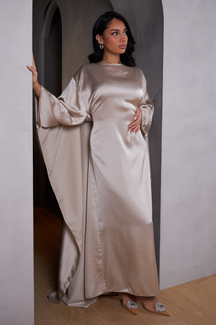 Robe ample ceinturée et satinée beige avec empiècement cape