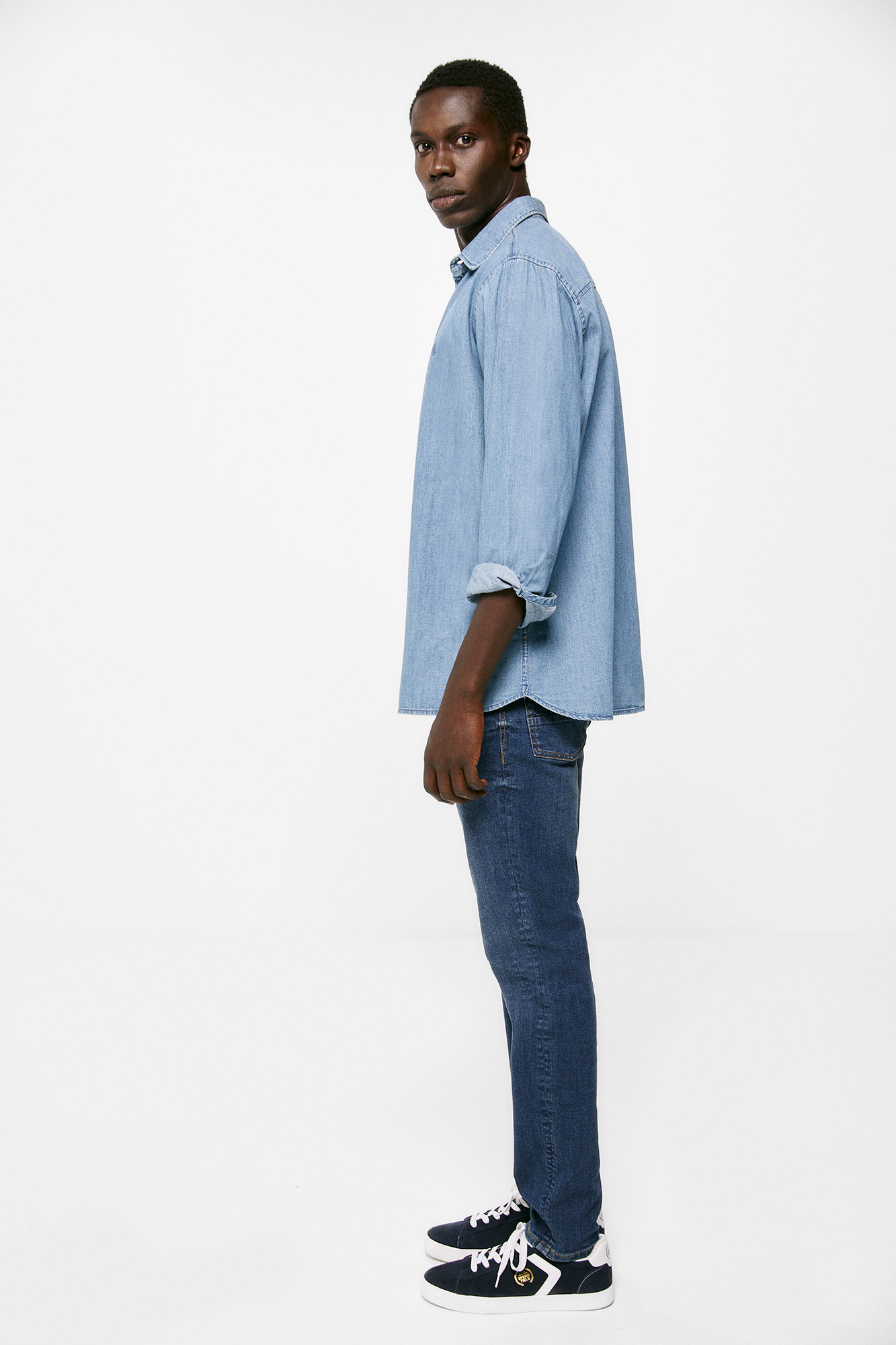 Calça jeans slim, lavagem clara escura, com detalhes desgastados.
