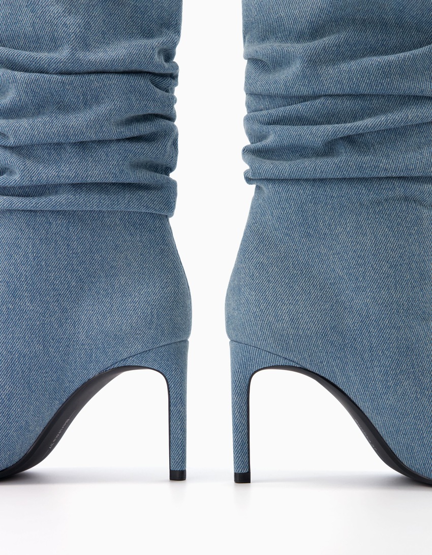 Botas de cano curto em jeans com salto baixo e modelagem folgada