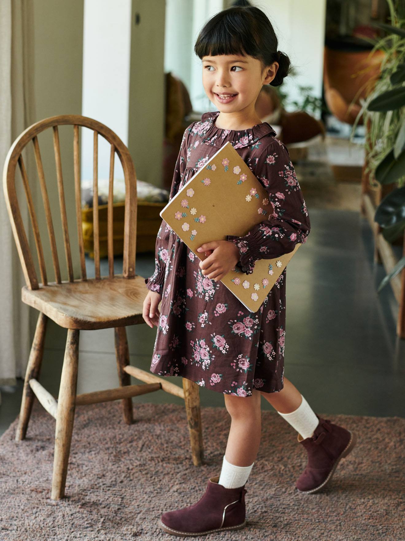 Vestido infantil com estampa floral e babados, na cor marrom escuro.