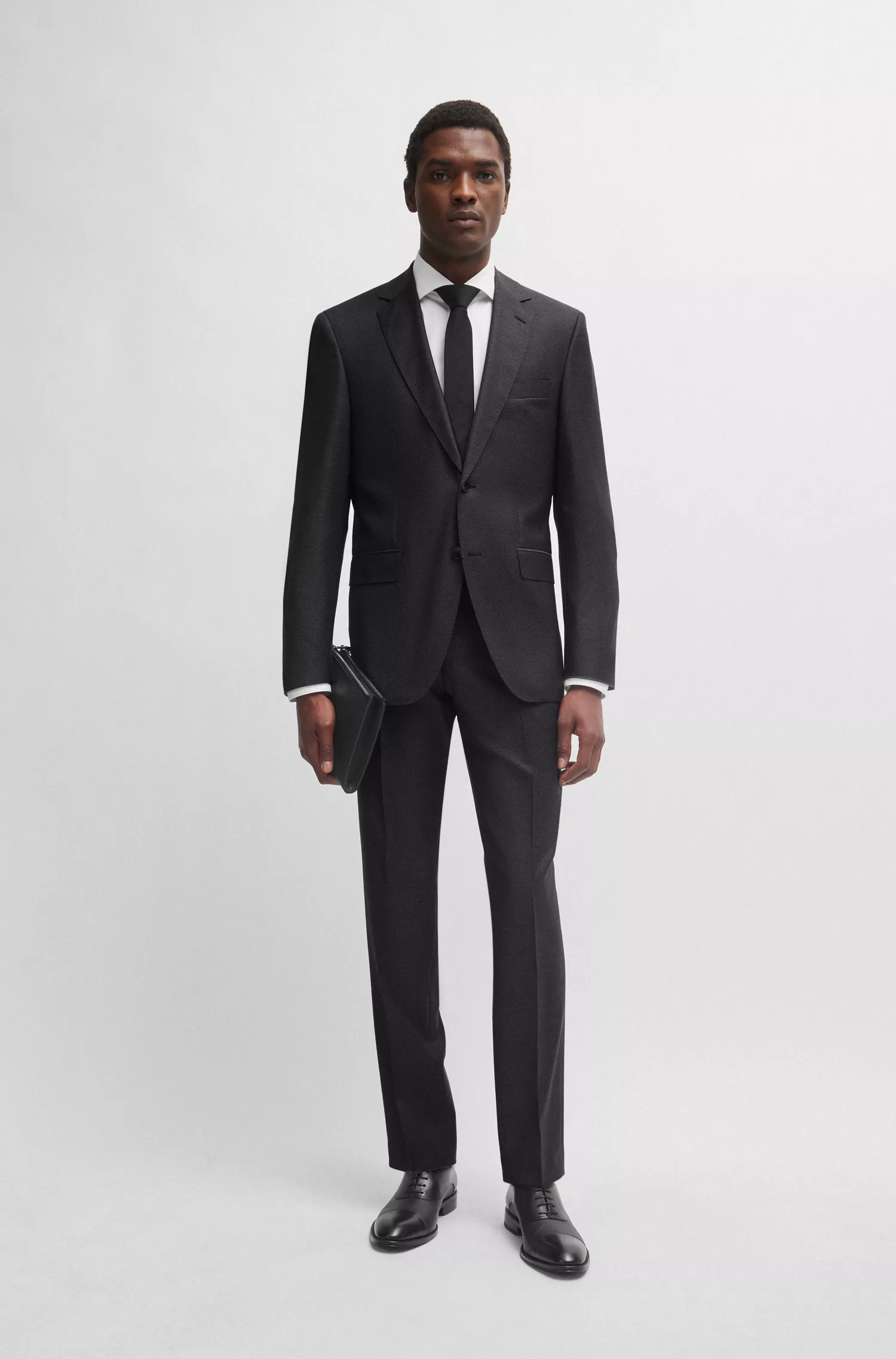 Terno BOSS preto, corte regular, em lã virgem com microestampa.