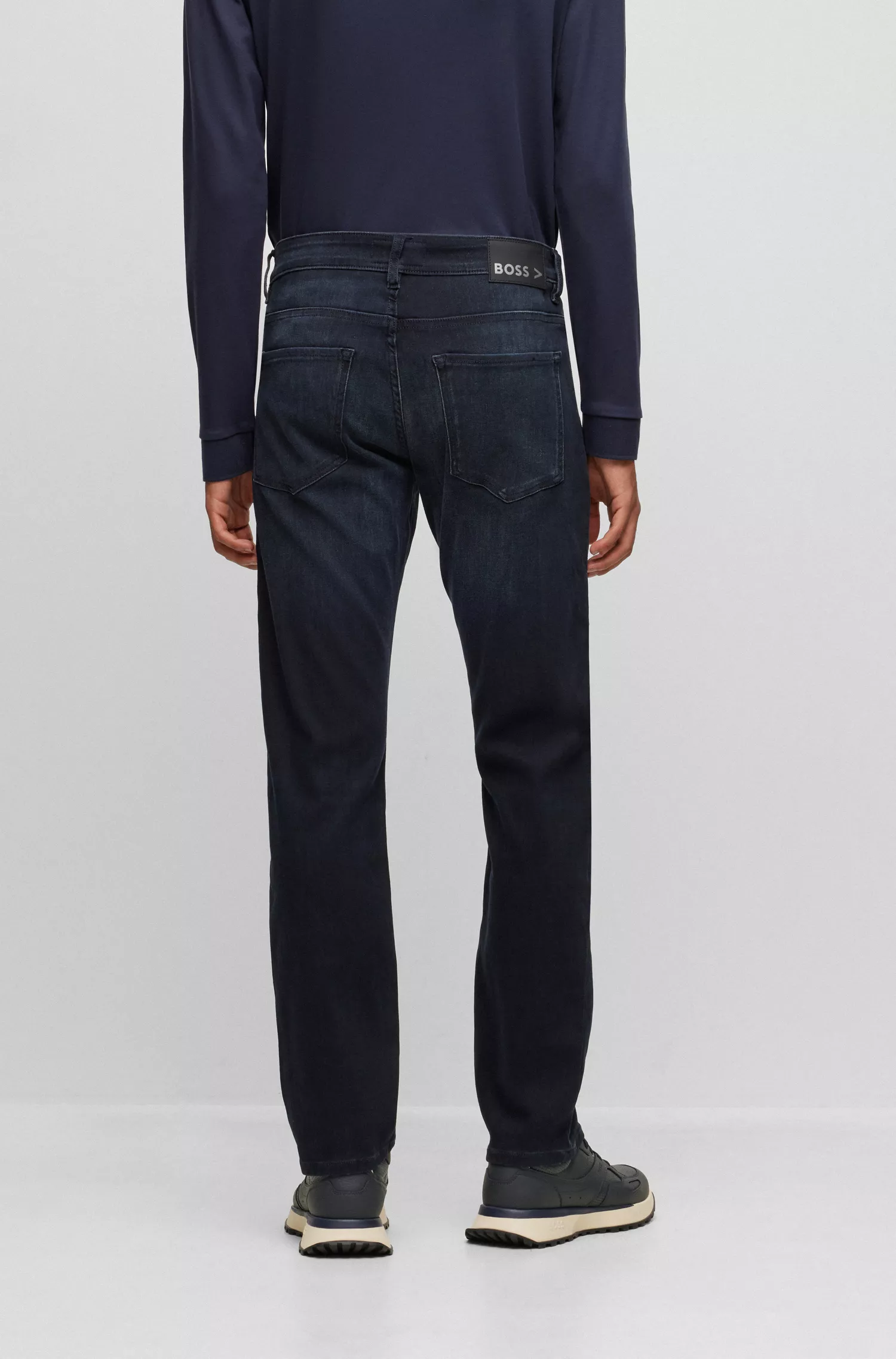 Calça jeans BOSS preta, corte slim, em denim de malha azul.