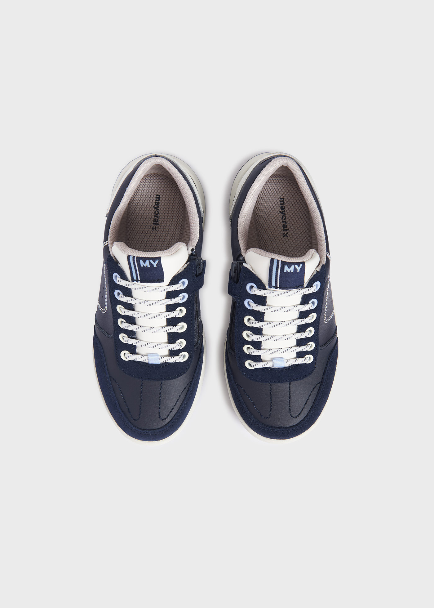 Jaqueta esportiva infantil com zíper lateral e detalhes perfurados.