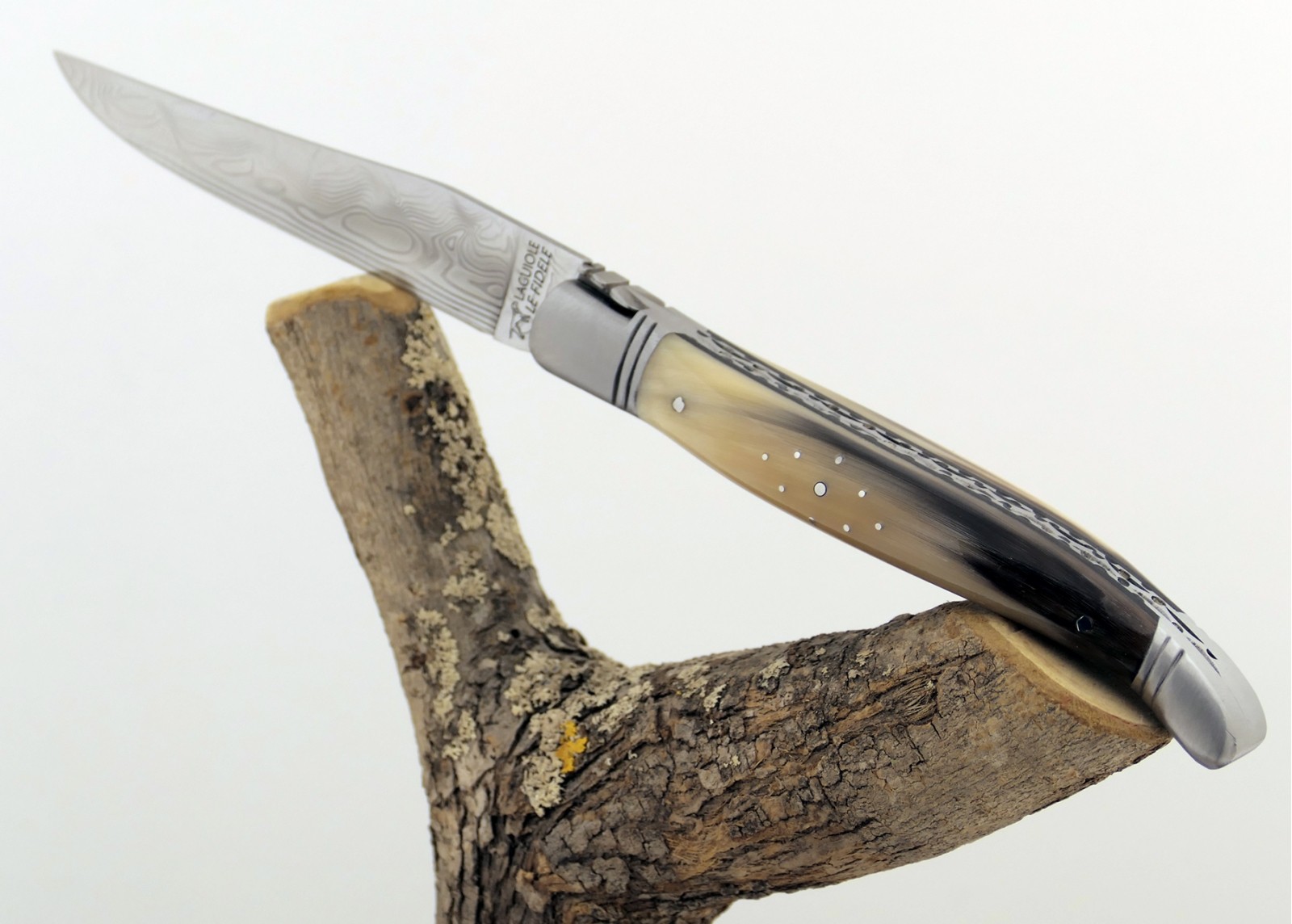 Couteau Laguiole prestige avec un manche en pointe de corne blonde et mitres en acier inoxydable et lame Damas