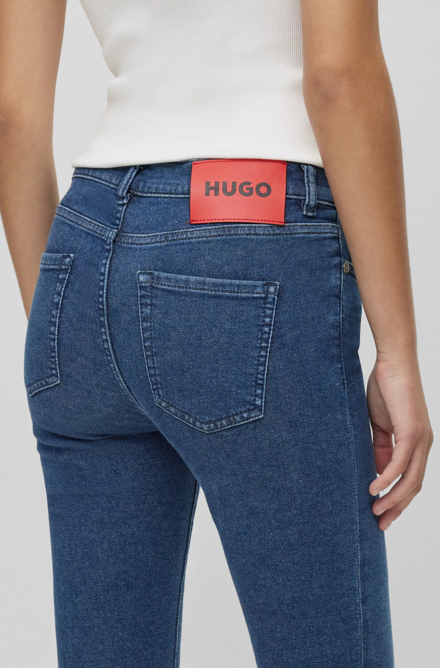 Calça jeans HUGO vermelha, extra slim fit, em denim elástico azul.