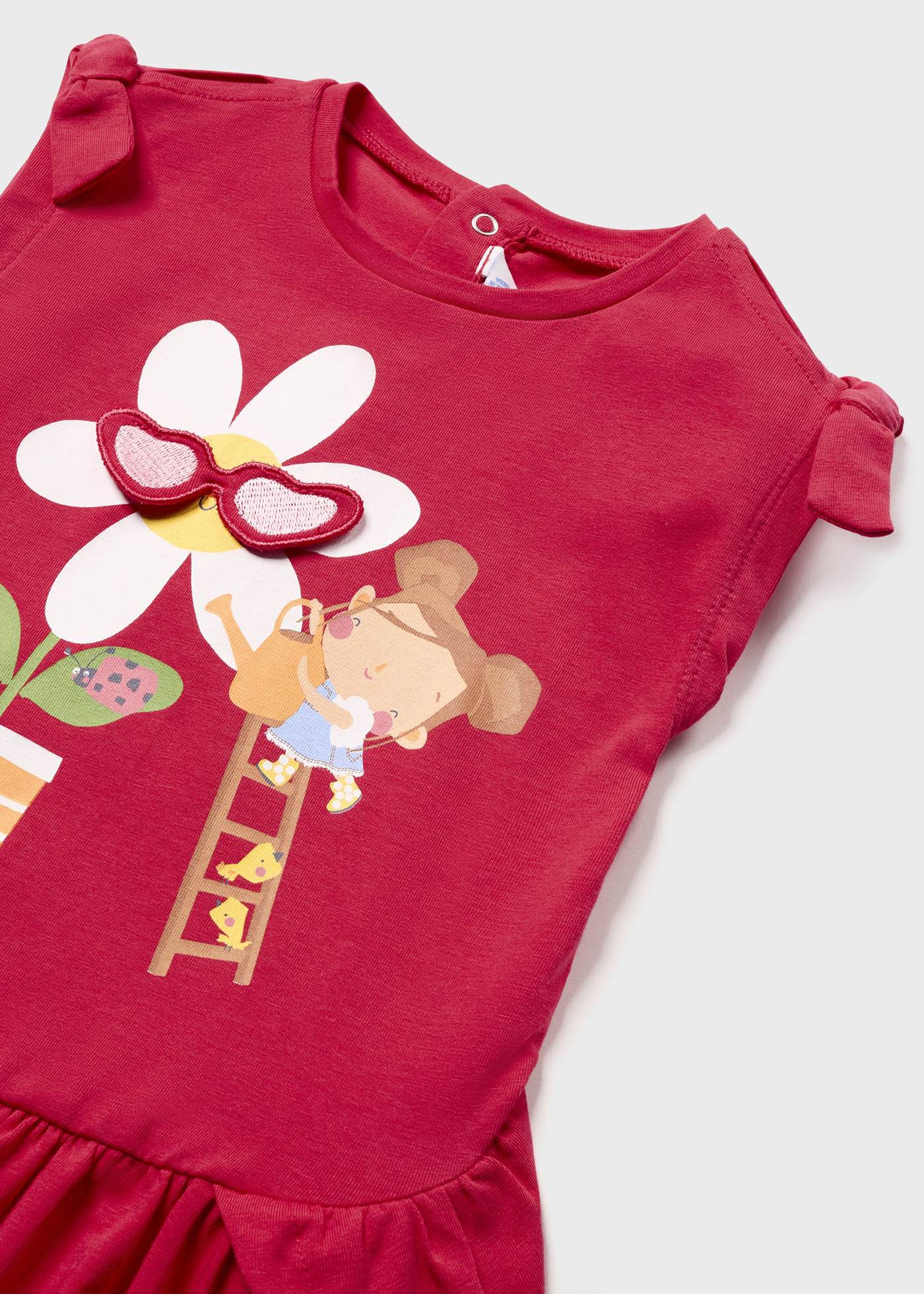 Vestido de bebê com estampa interativa feito de algodão sustentável.