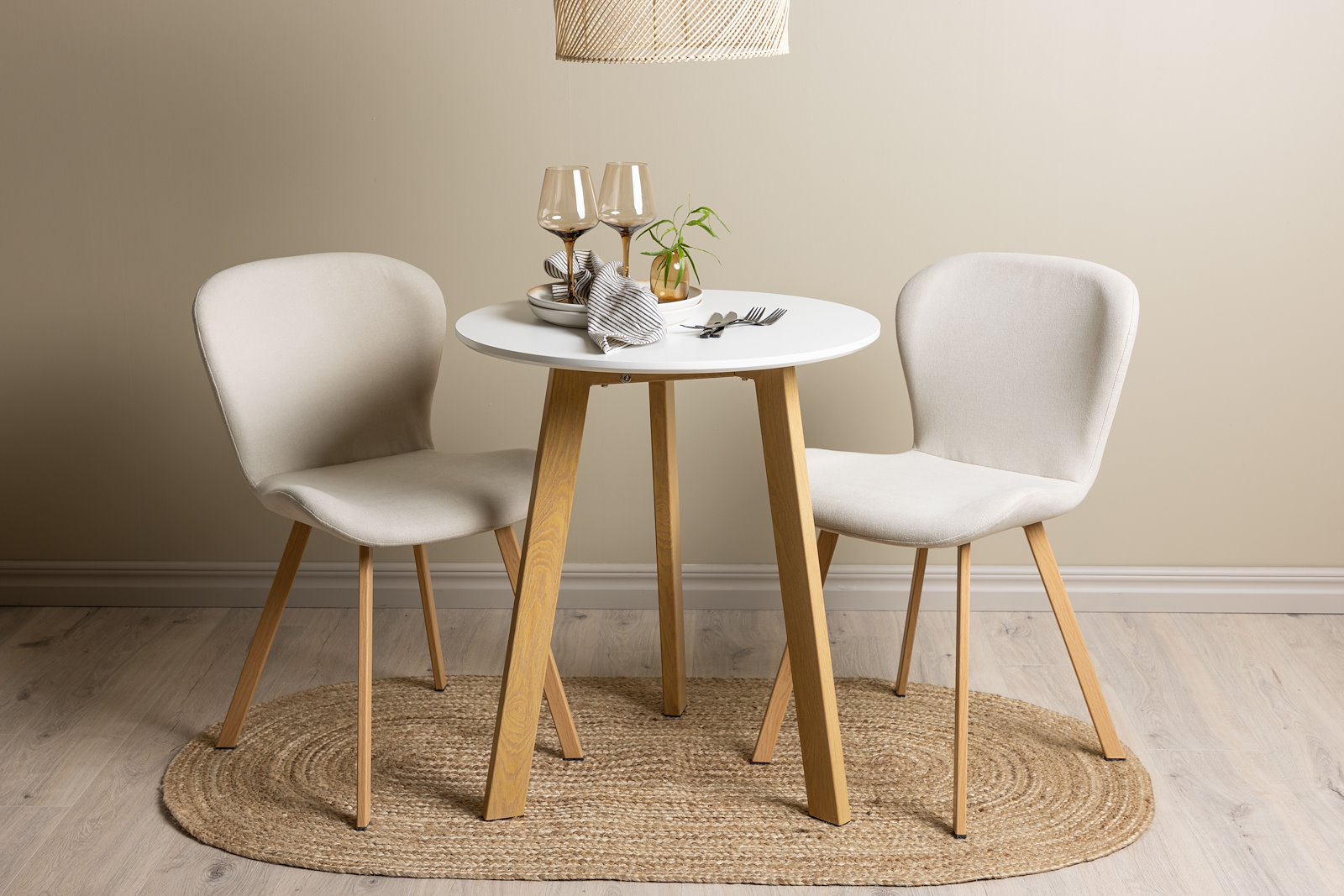 Leonora og Lilja Spisegruppe Leonora rundt spisebord Ø65 cm i hvit og eikeben med 2 stk. Lilja spisestoler i Beige og eik ben.