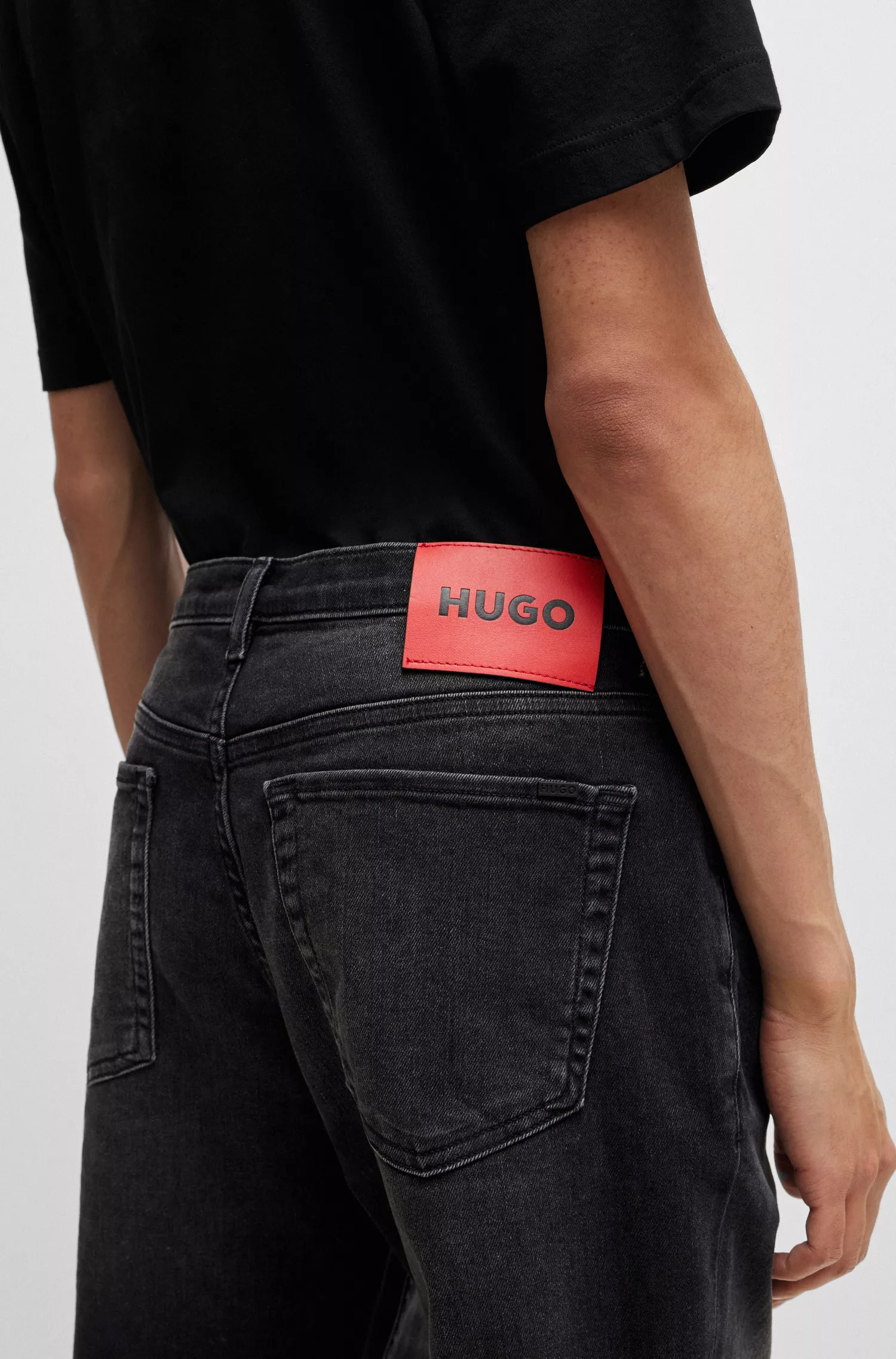 Calça jeans HUGO vermelha, corte afunilado, em denim preto com elasticidade confortável.