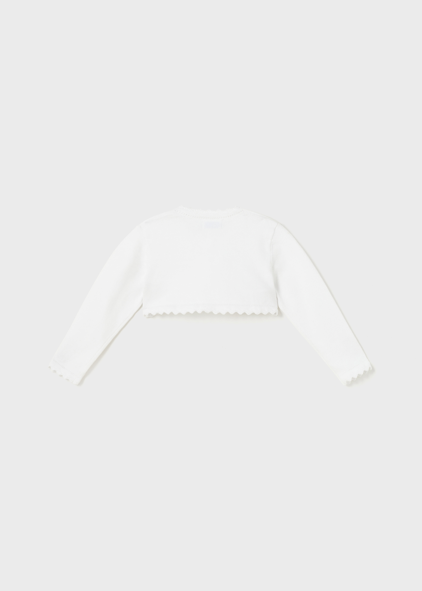 Casaquinho estilo bolero para bebê, confeccionado em algodão sustentável.