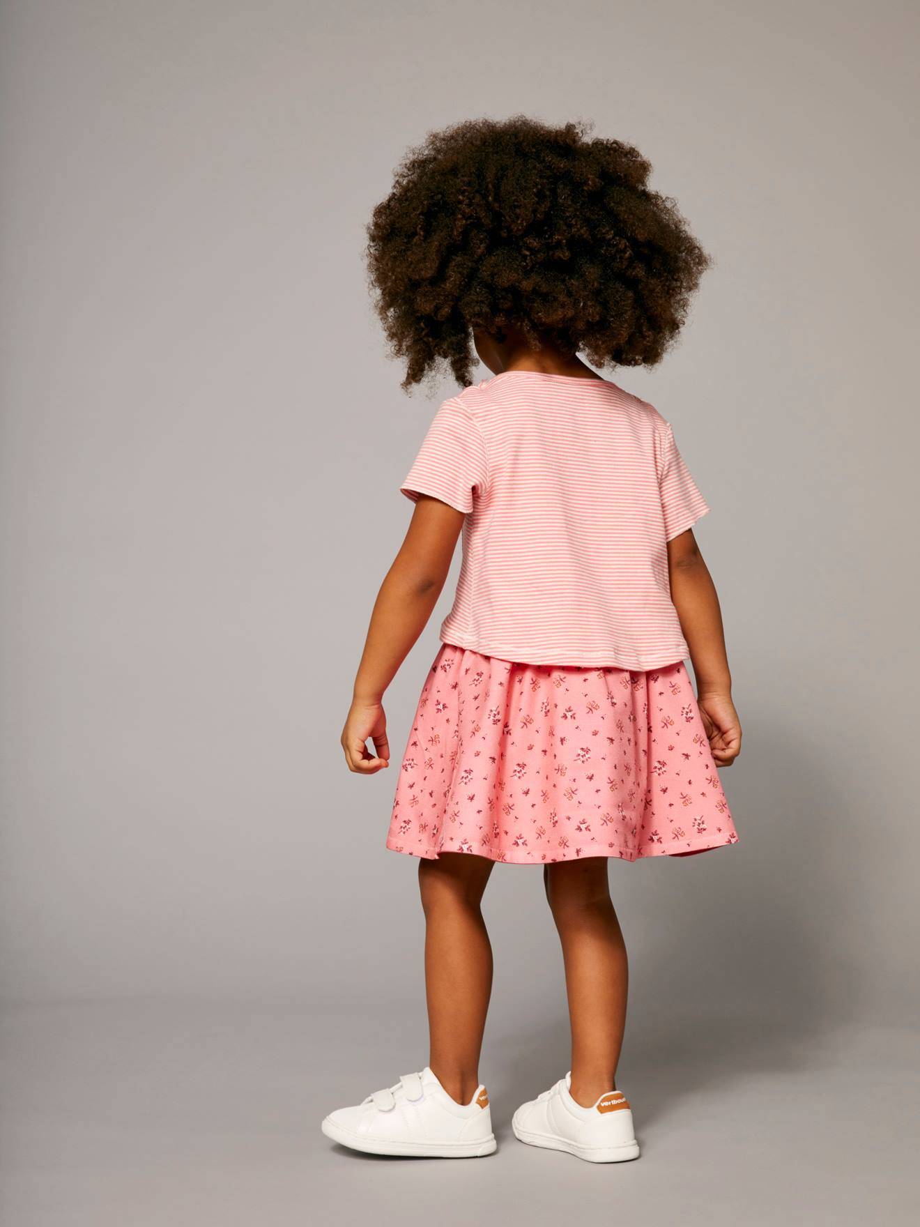 Vestido reversível para meninas em dois tecidos estampados rosa claro.