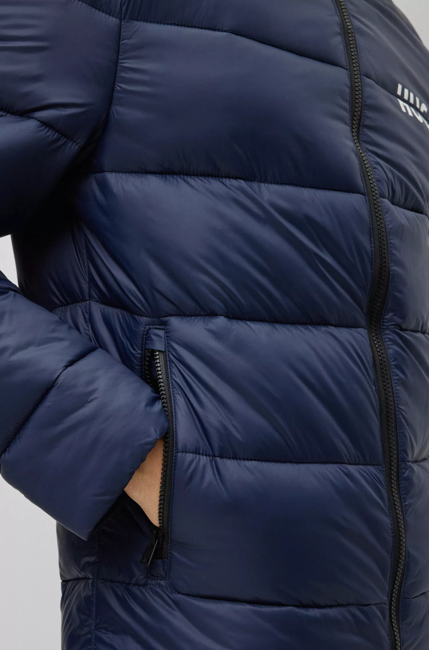 Jaqueta puffer HUGO vermelha, corte slim, com logo dividido.