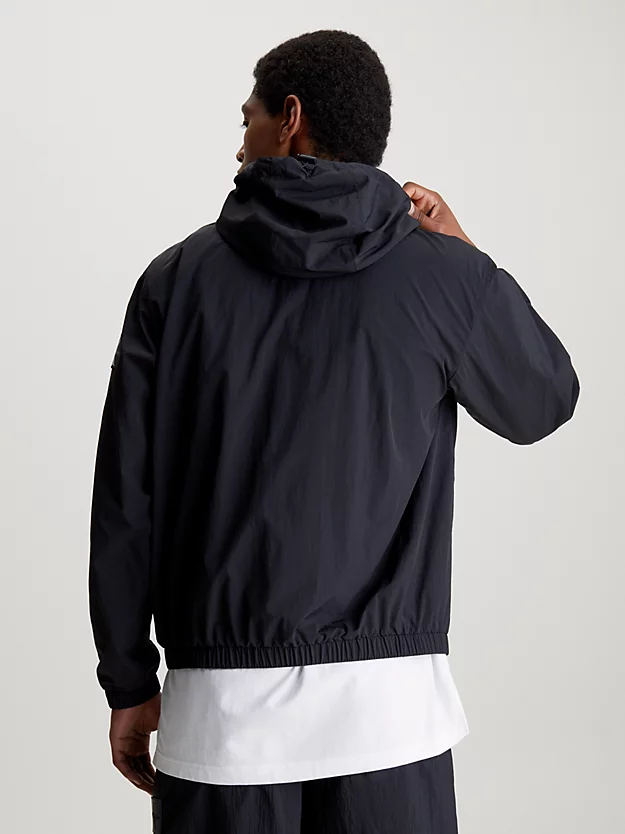 Jaqueta corta-vento de nylon com modelagem folgada e capuz.