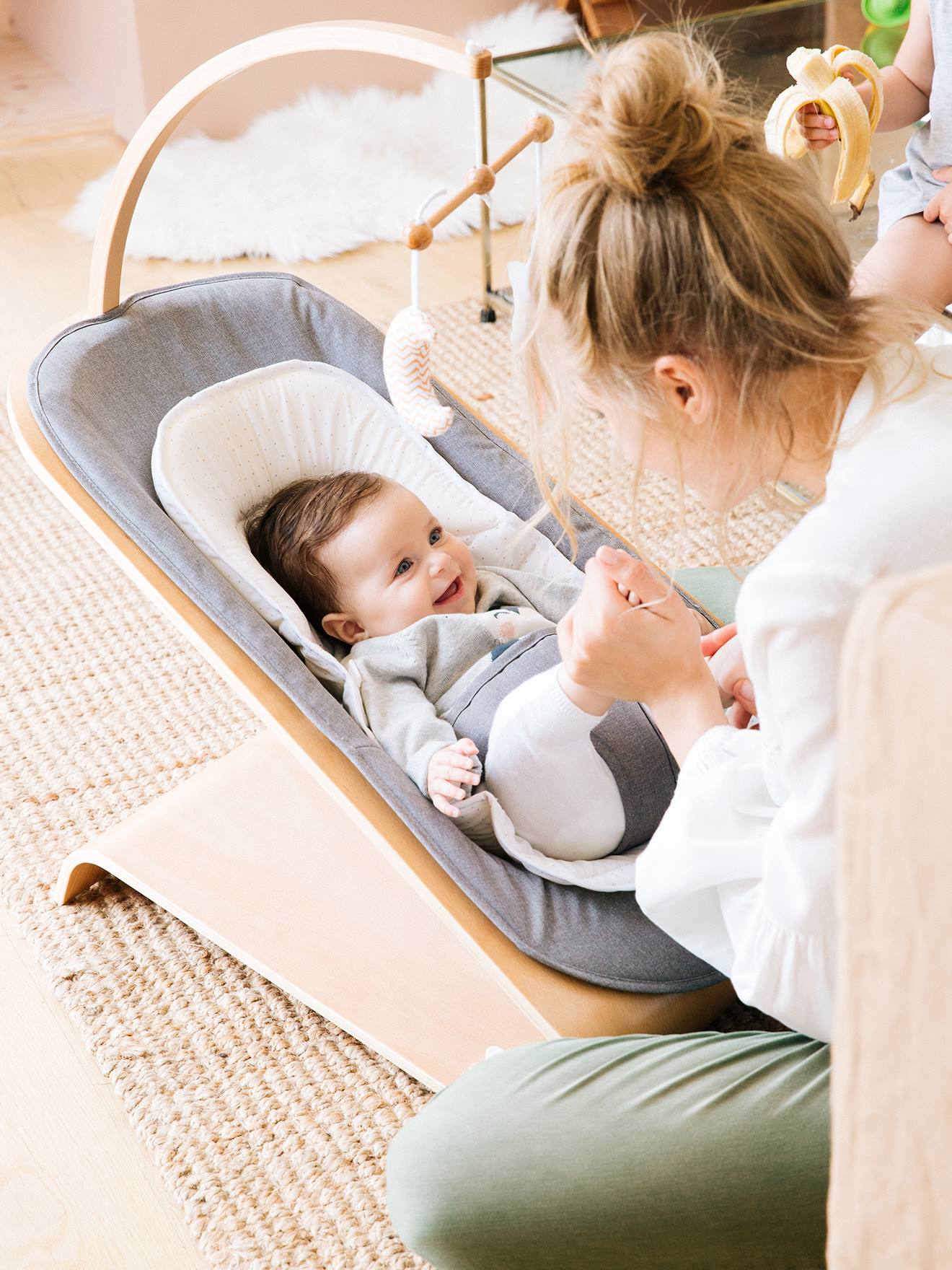 Rede de madeira lisa cinza claro Vertbaudet Babyrythm com movimento de balanço natural e motivos decorativos.