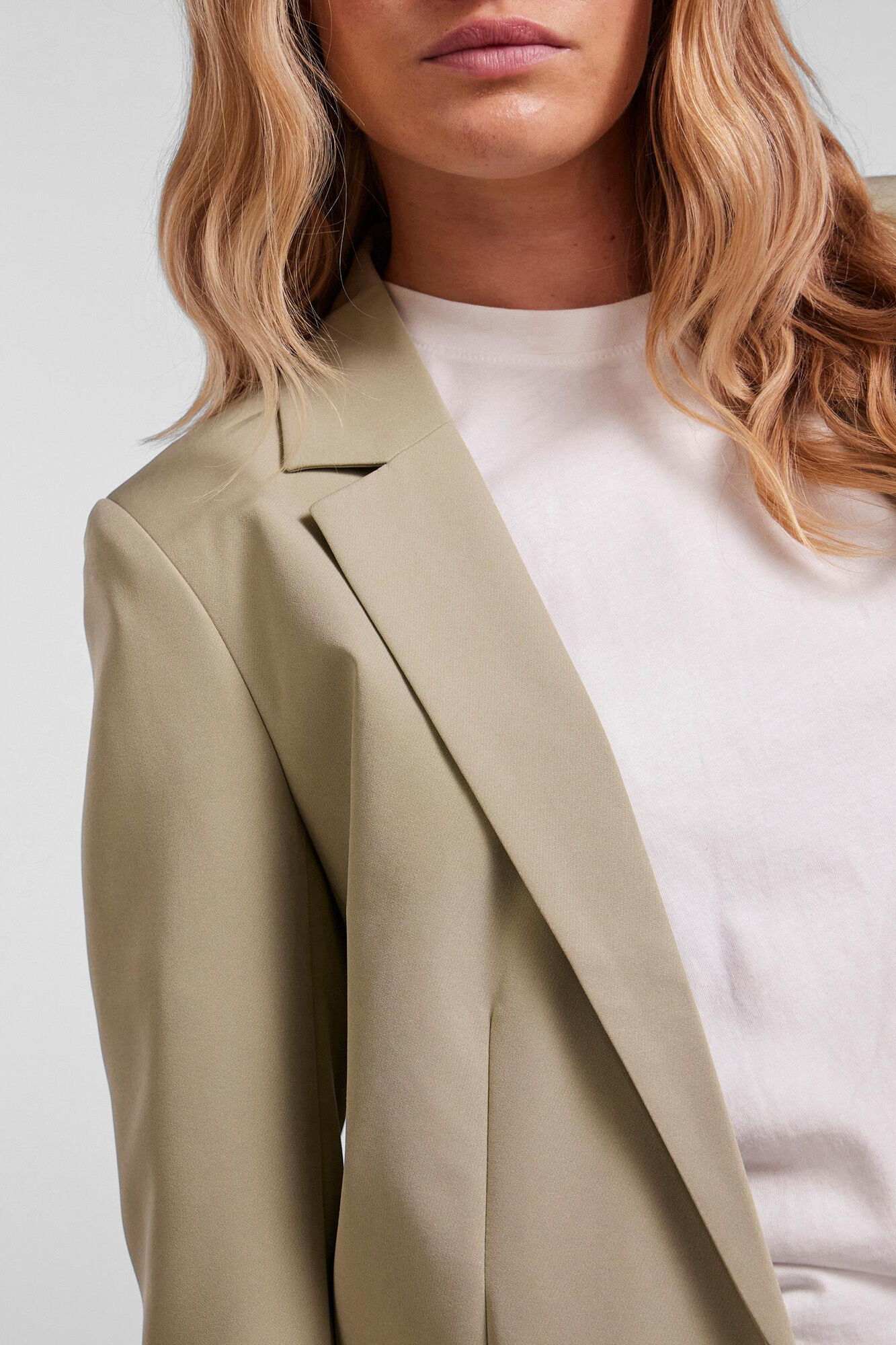 Blazer oversized com mangas compridas, bolsos falsos e lapela no decote.