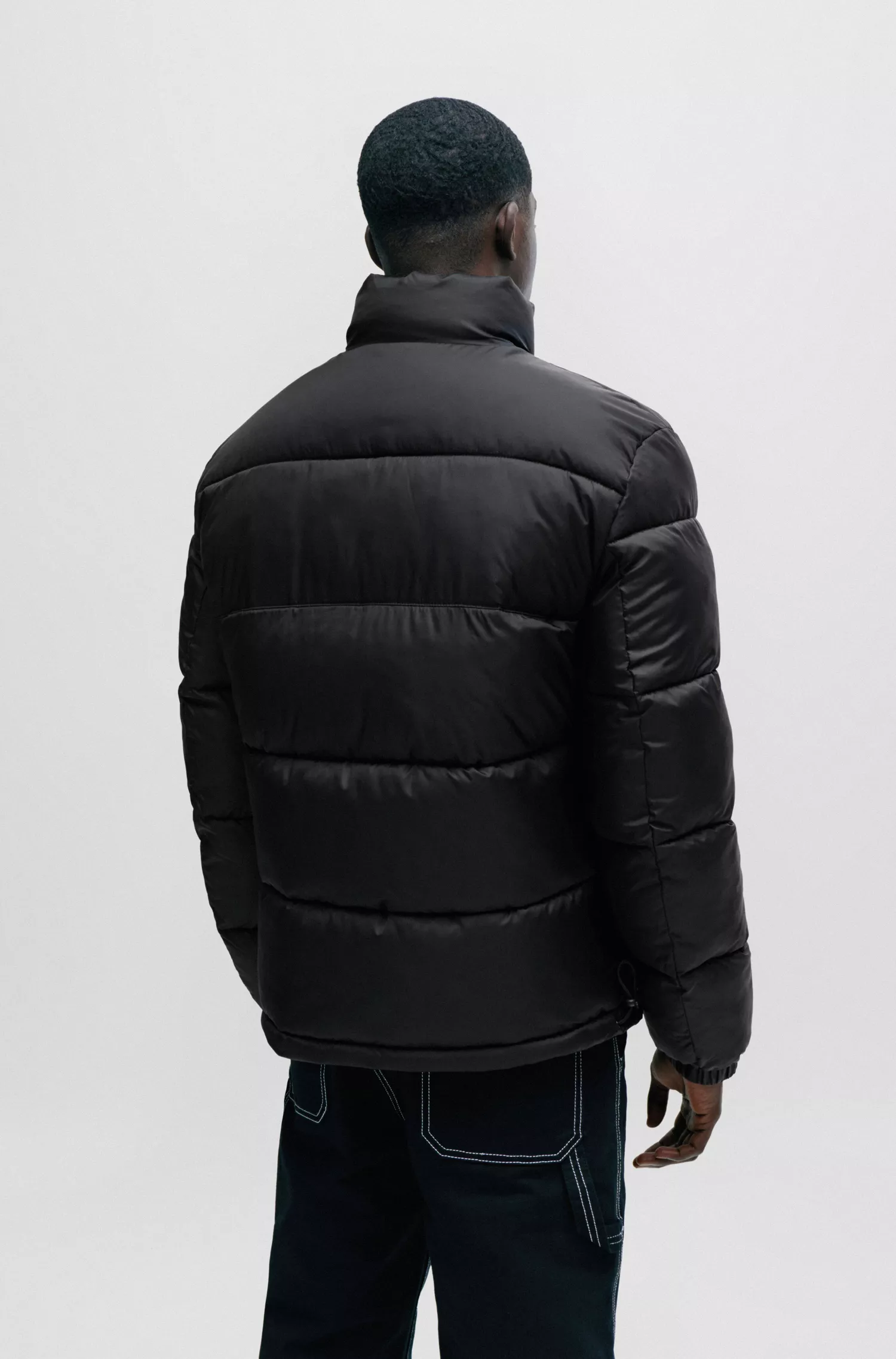 Jaqueta puffer HUGO vermelha, impermeável, com emblema vermelho da marca.