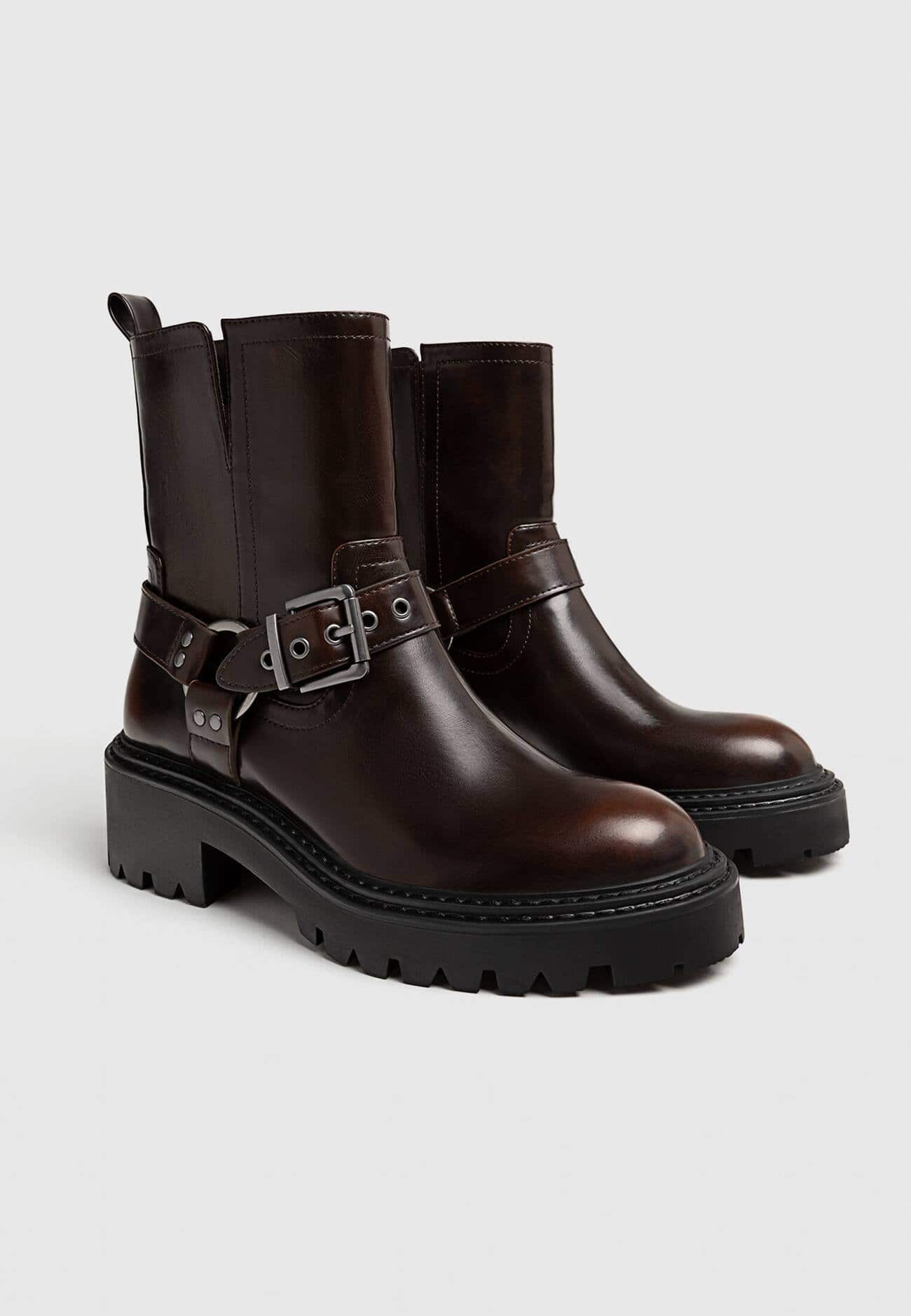 Botas de cano curto estilo motociclista, sem salto, com detalhes de fivela.