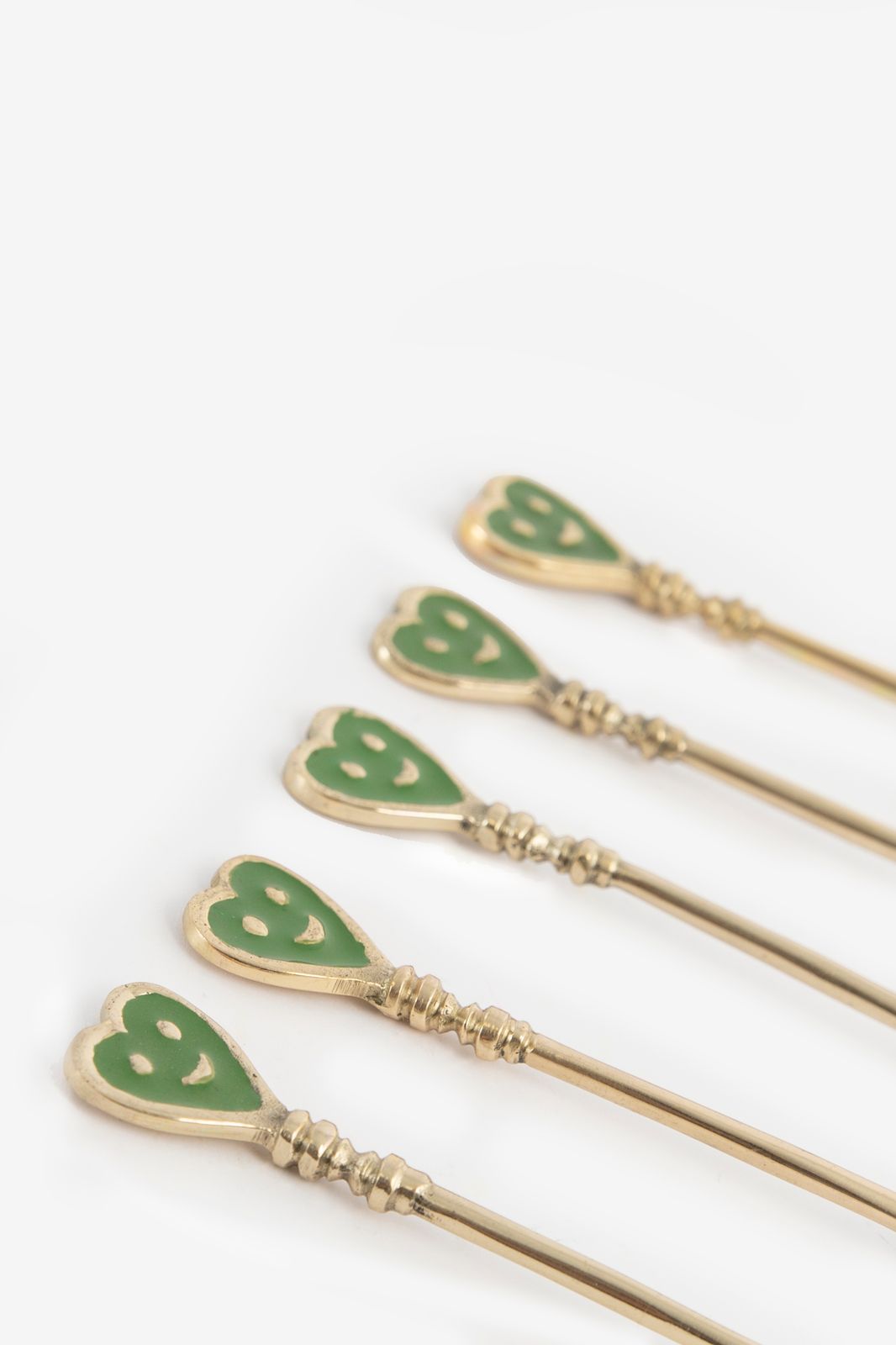 Groene en goudkleurige theelepels met smiley hartjes