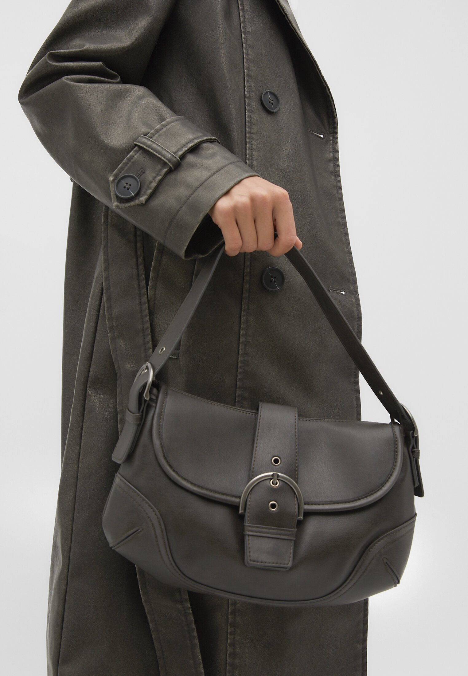 Bolsa de ombro com acabamento desgastado e fivela.