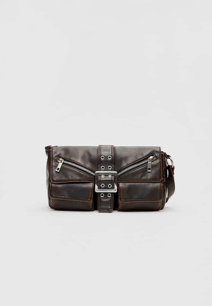Bolsa de ombro com acabamento desgastado e bolsos.