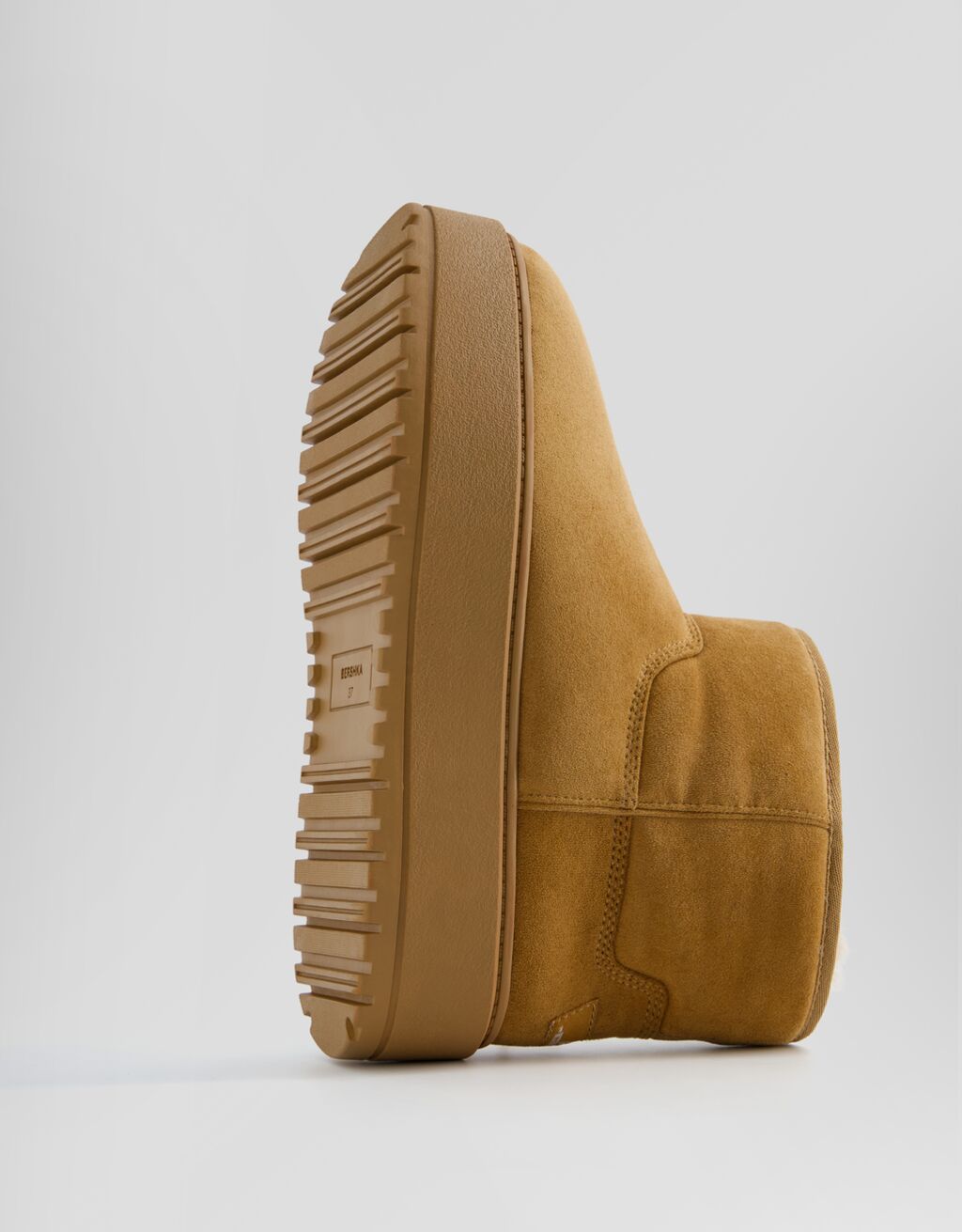 Botas de cano curto com plataforma e forro de pele sintética.