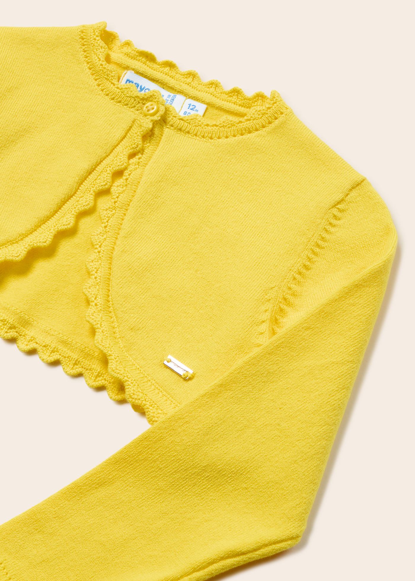 Casaquinho estilo bolero para bebê, confeccionado em algodão sustentável.
