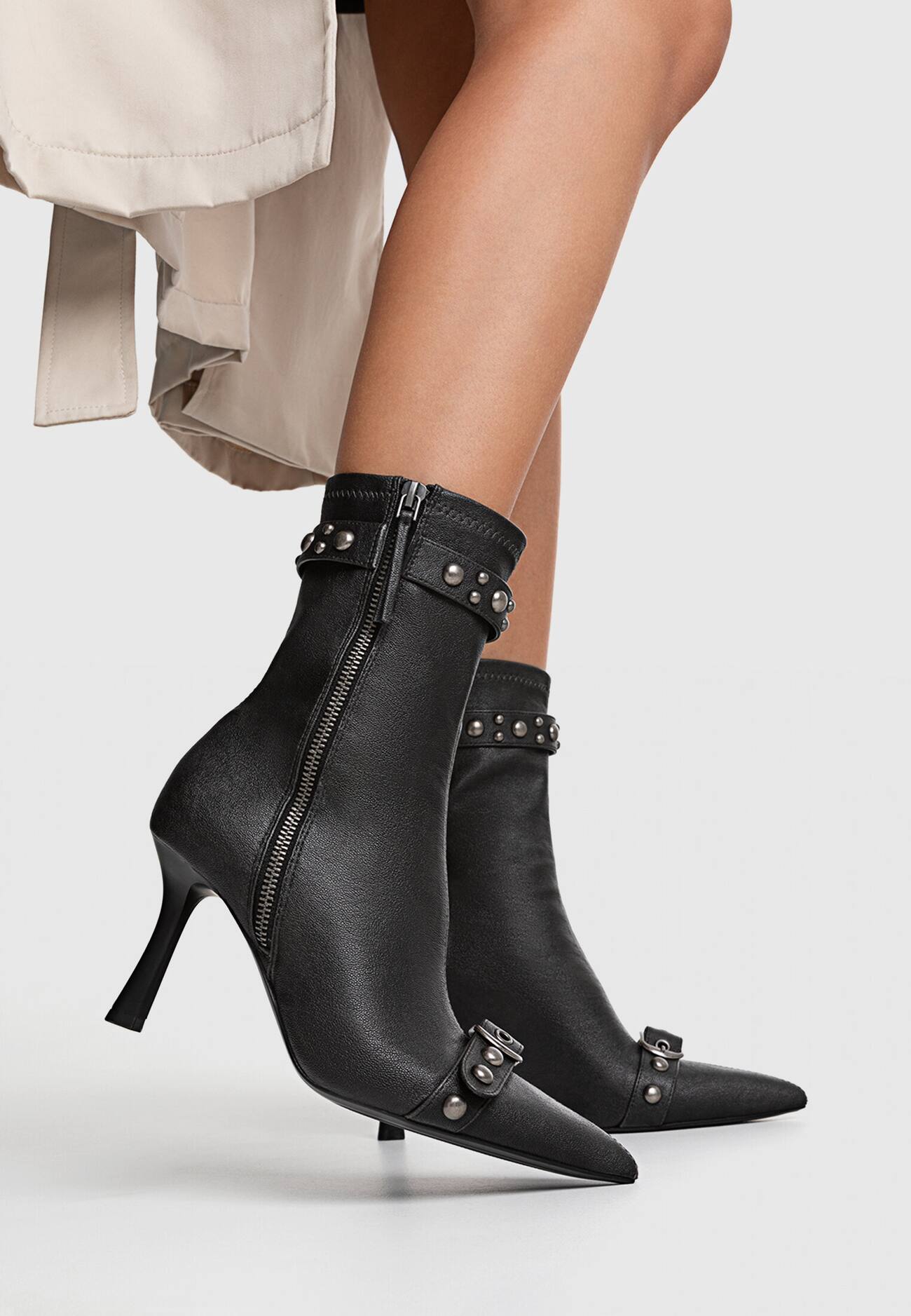 Botas de cano curto com tachas e fivelas em estilo desgastado.