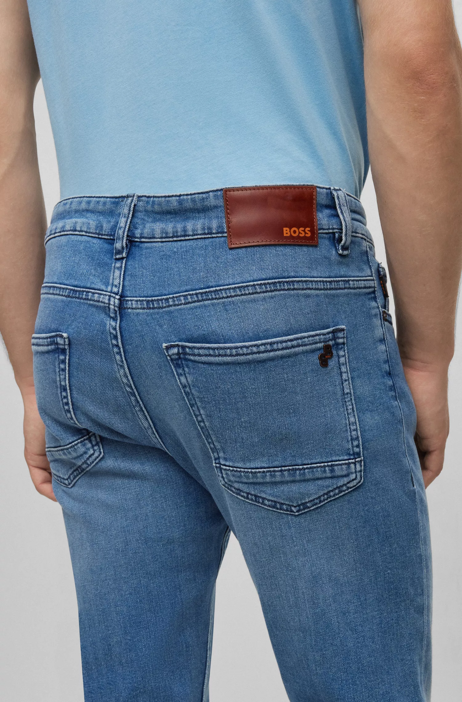 Calça jeans BOSS laranja, corte slim, em denim azul com elasticidade confortável.