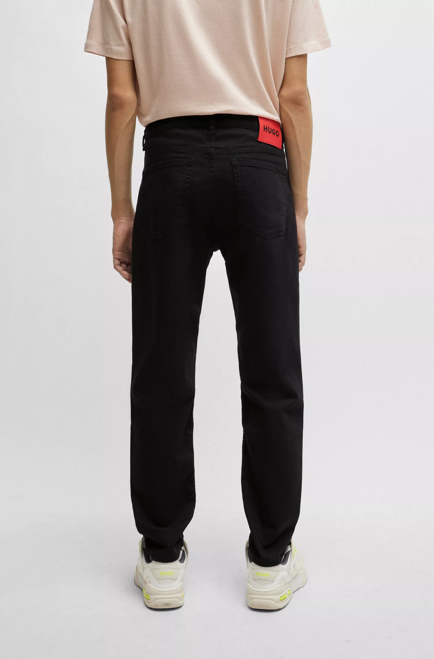 Calça jeans HUGO vermelha, corte afunilado, em denim preto com elasticidade confortável.
