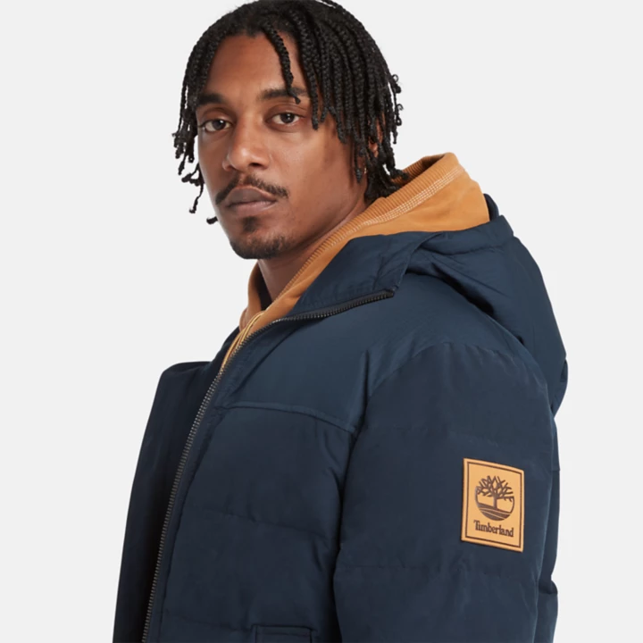 Jaqueta puffer impermeável com capuz Mountain Welch para homens na cor azul marinho.