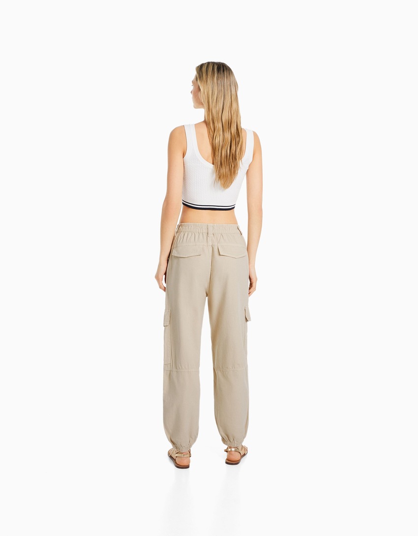 Calças de algodão com cintura franzida e bolsos.
