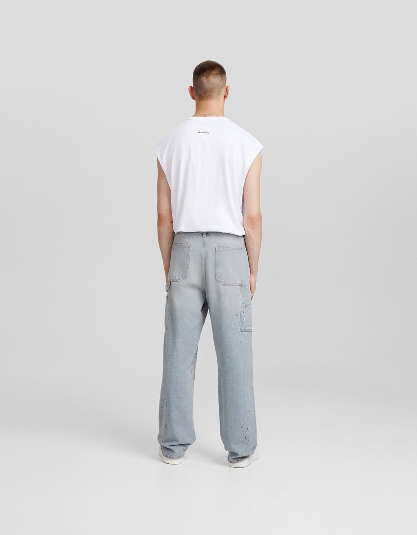 calça jeans de carpinteiro com respingos de tinta