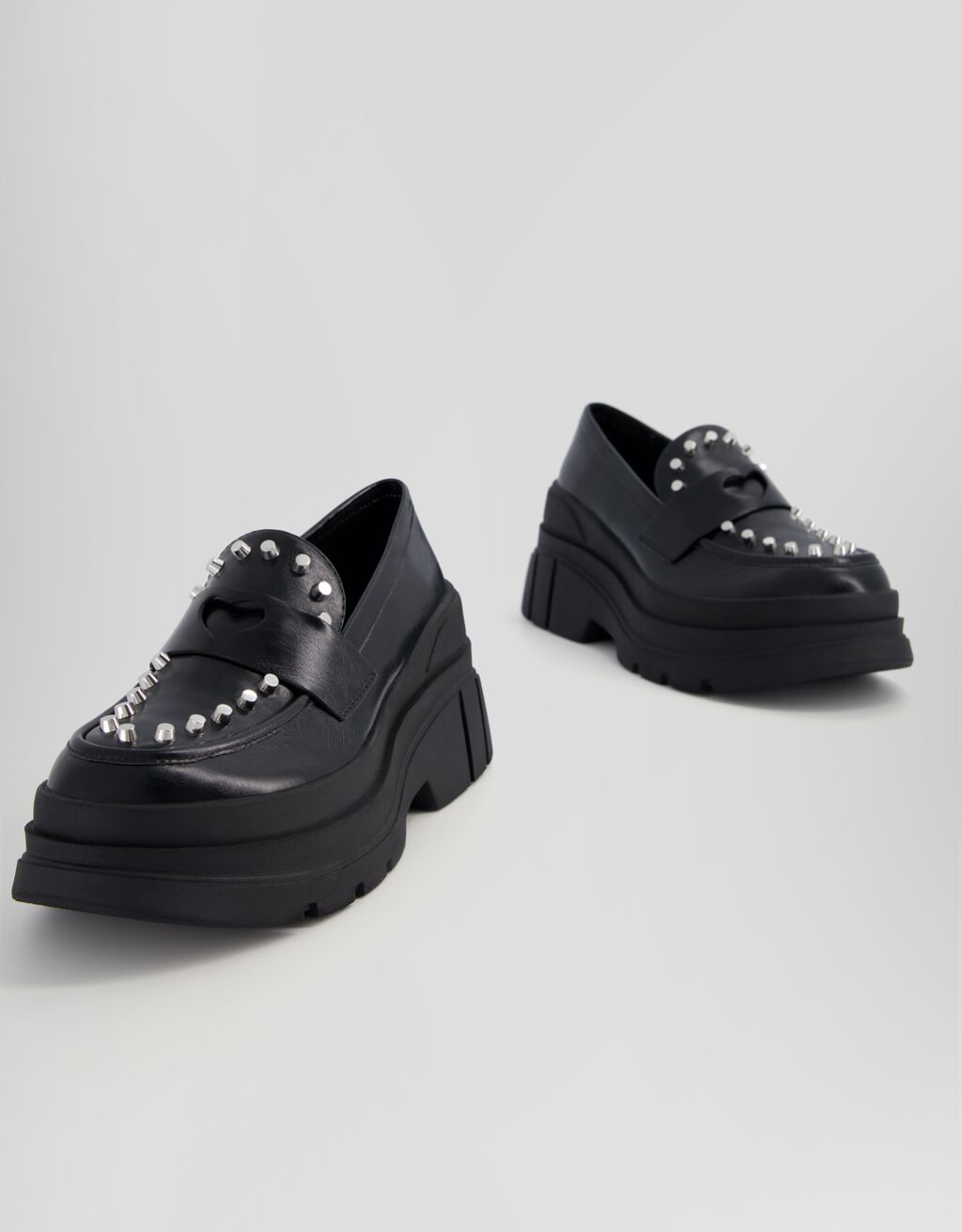 Mocassins com tachas e solado grosso.