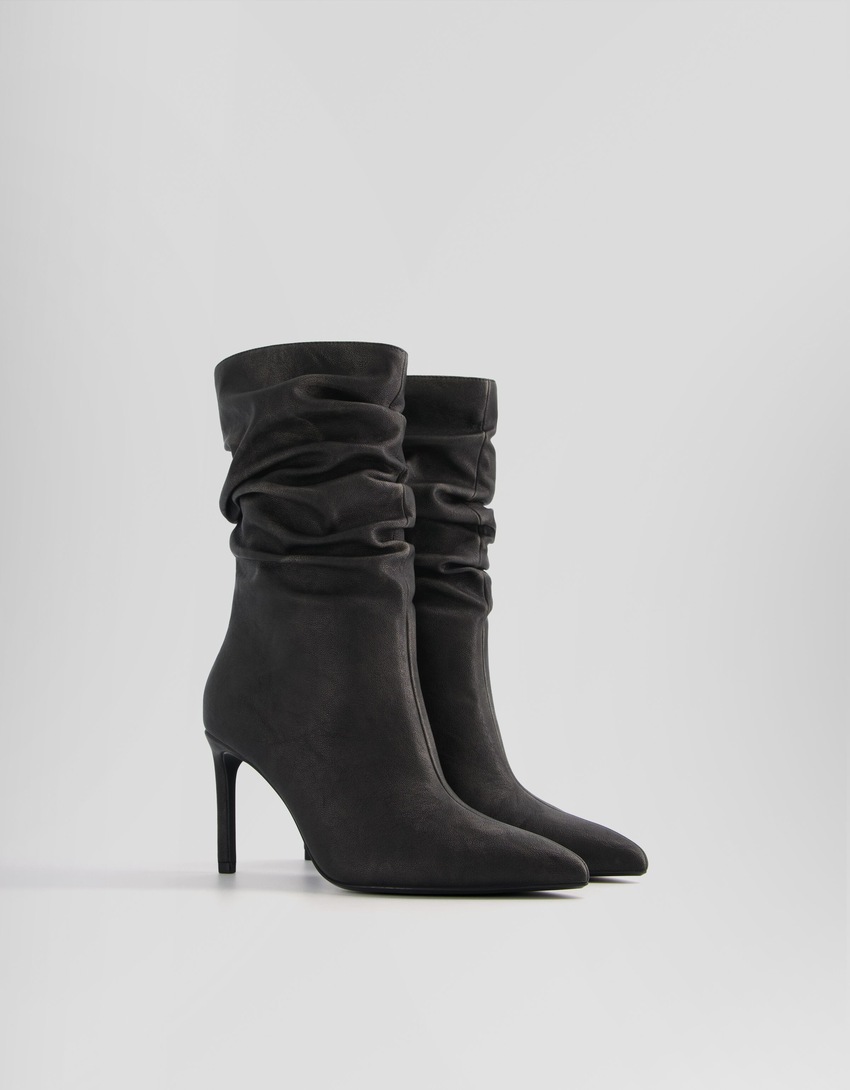 Botas de cano curto com salto agulha e modelagem folgada
