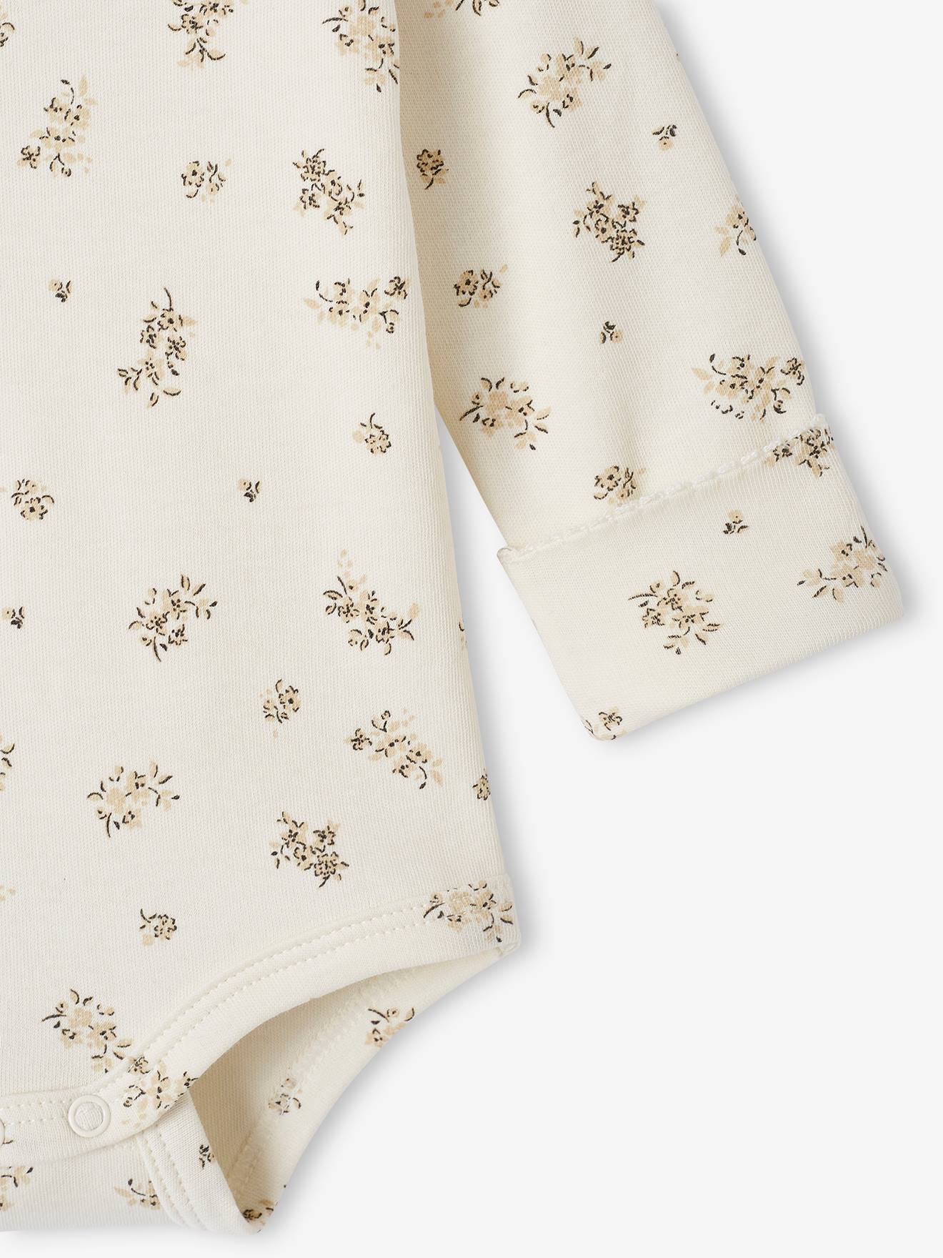 Body de bebê em tons naturais com estampa floral e gola Peter Pan.