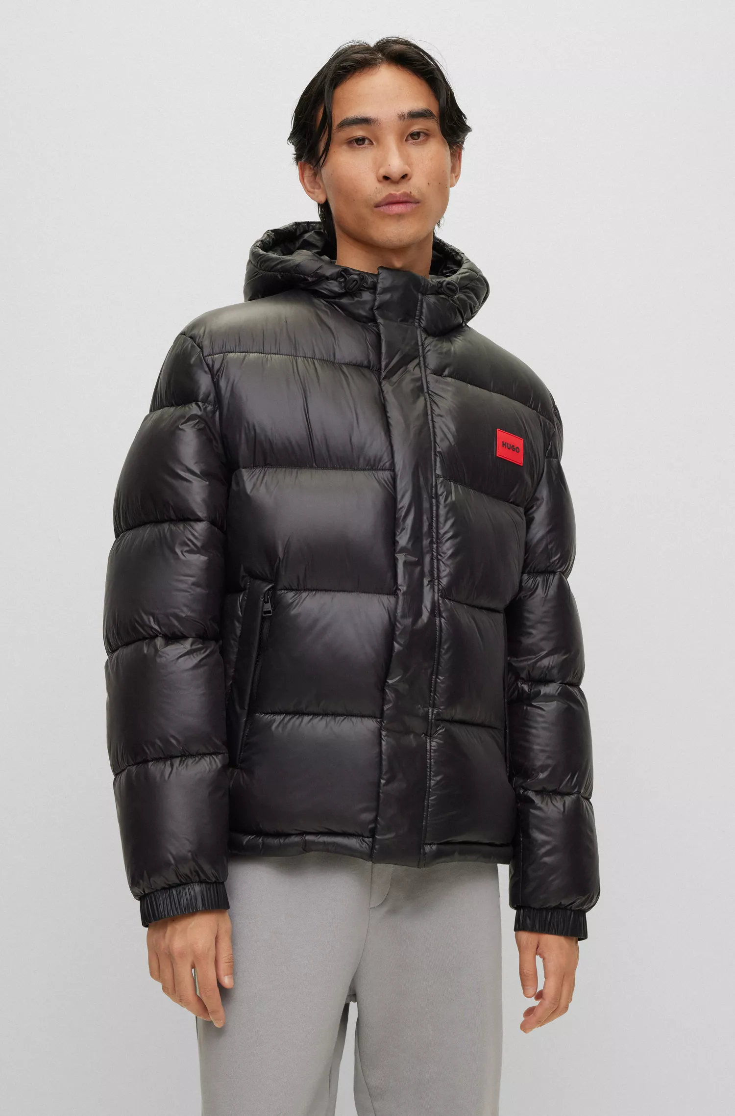 Jaqueta puffer slim fit HUGO vermelha, repelente à água e com emblema da marca.