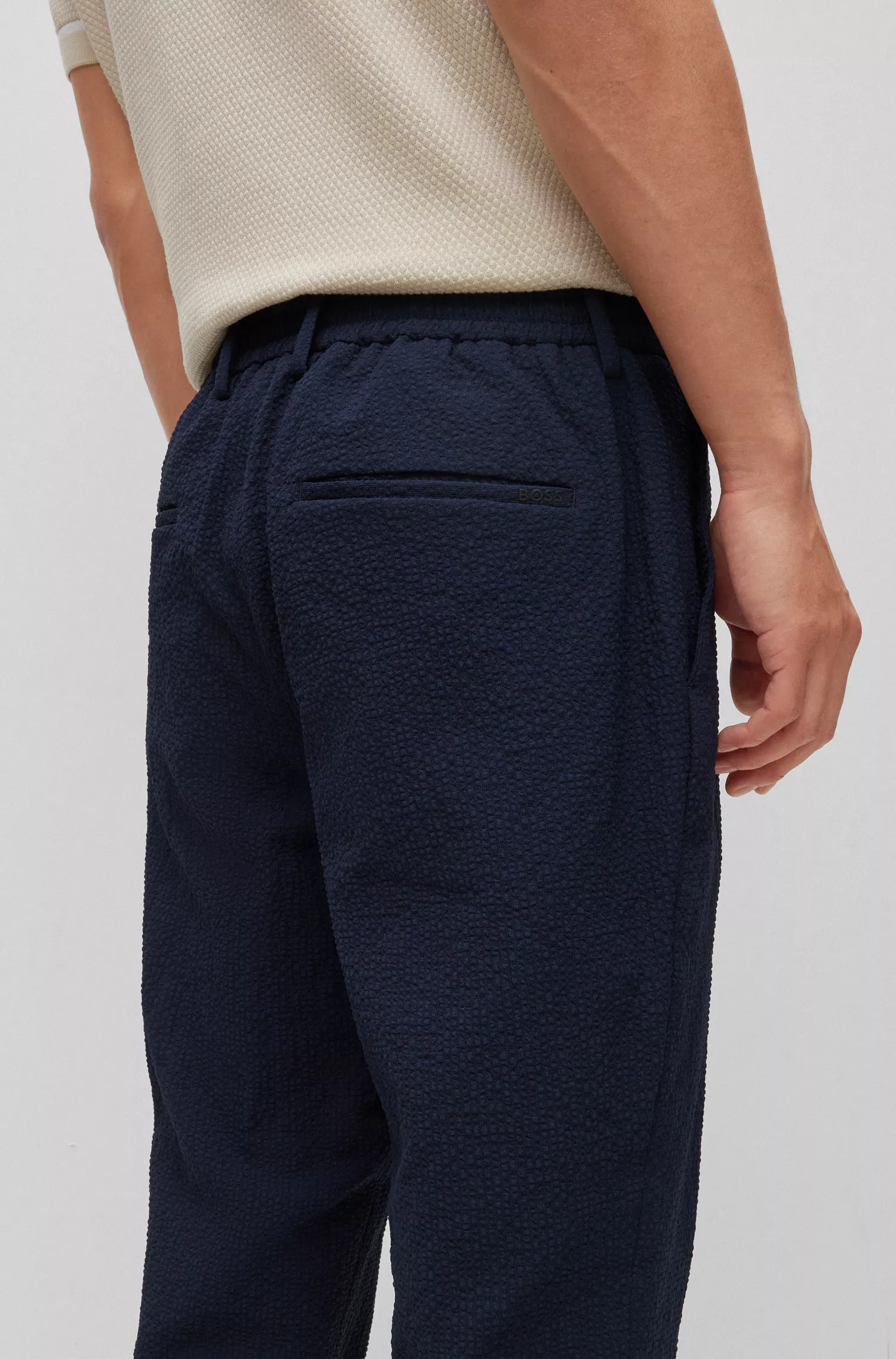 Calça BOSS preta de corte slim em tecido seersucker de alta performance com elasticidade.