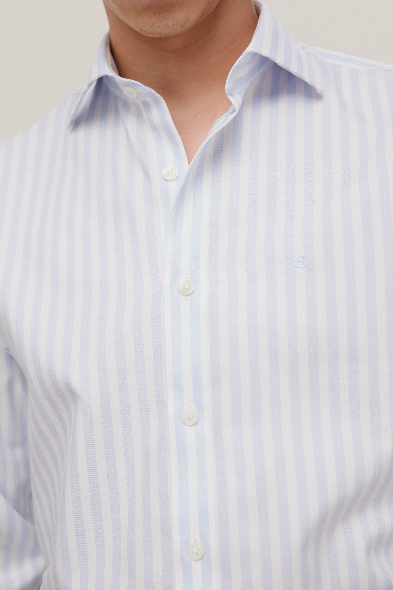 Camisa social listrada, azul, que não precisa passar e é resistente a manchas.