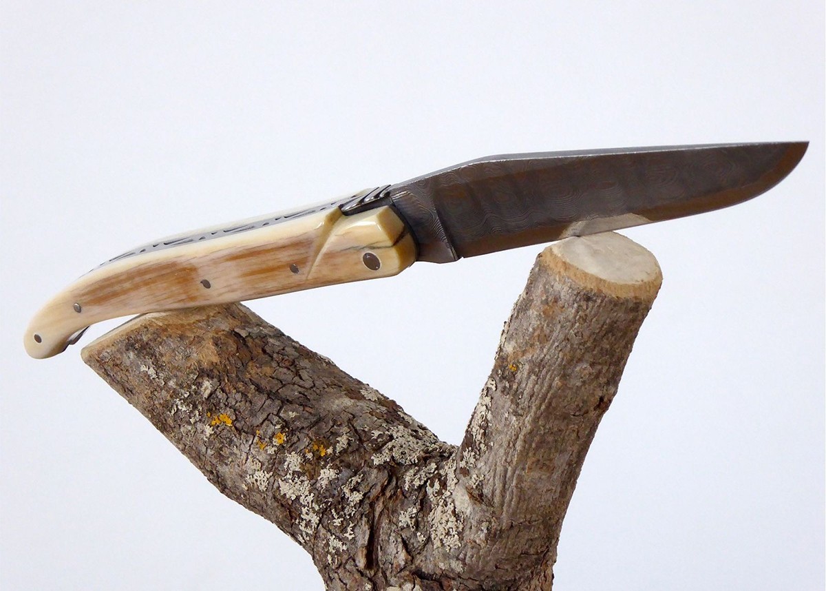 Couteau Laguiole avec une lame Damas et un manche en ivoire de Mammouth plein manche