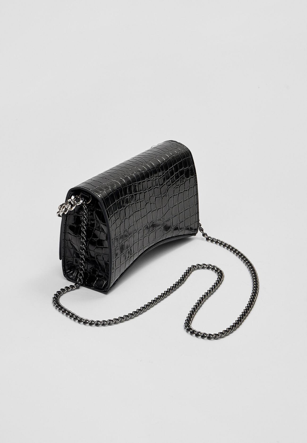 Bolsa transversal imitando crocodilo com corrente.