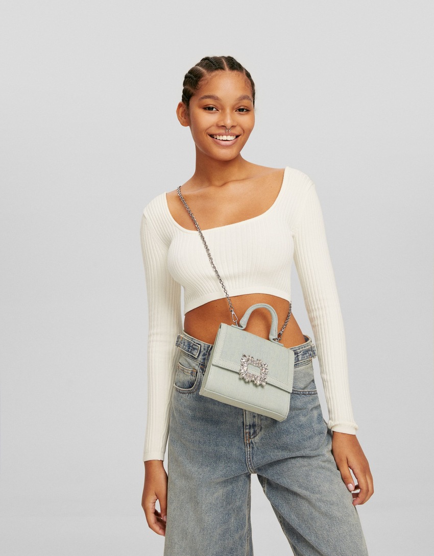 Bolsa transversal multifuncional em jeans com aplicações de miçangas e corrente.