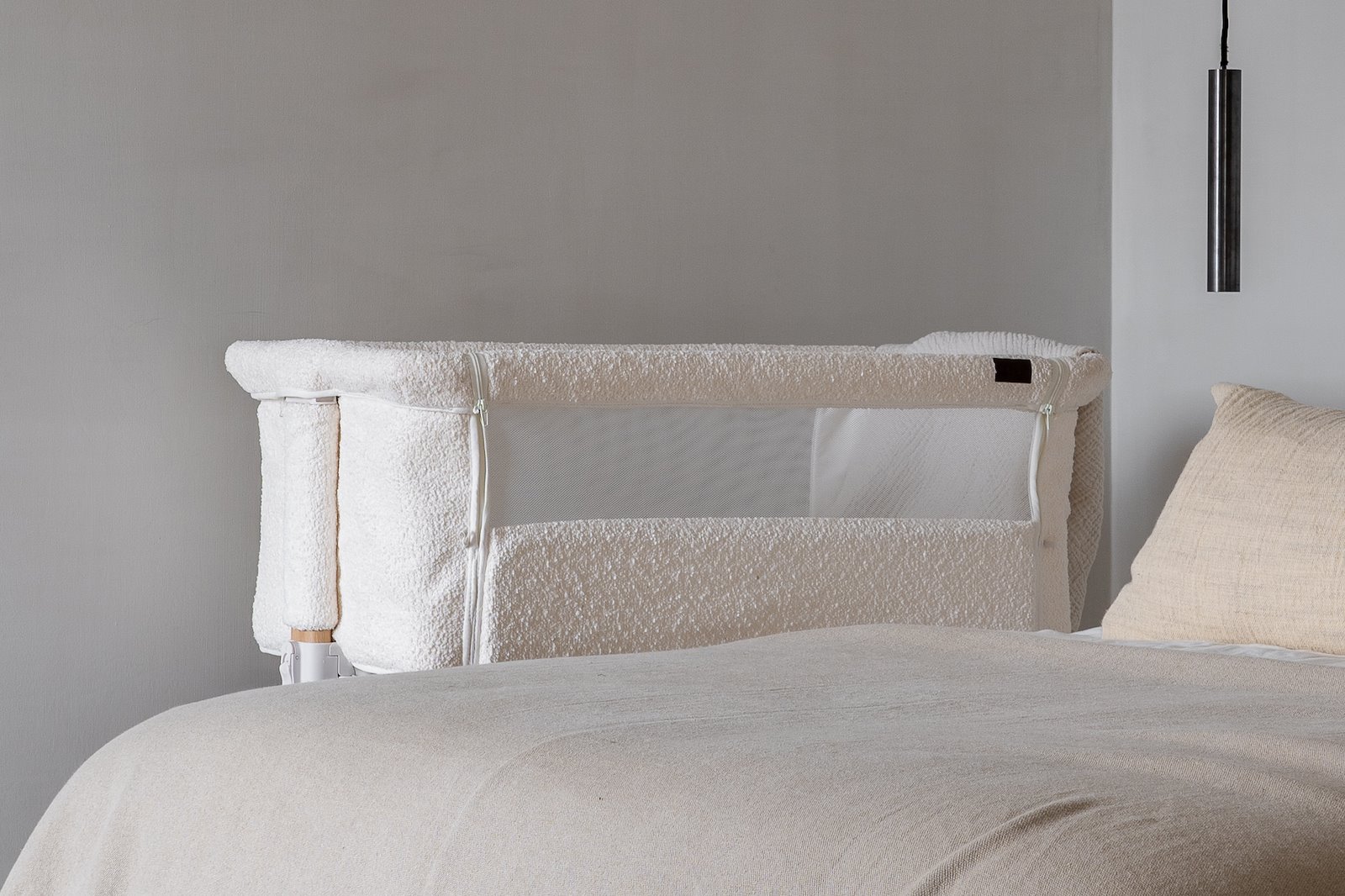Beddo Bedside Crib Bedside crib i hvitt, mykt bouclétekstil og trelignende understell. Justerbar i høyden.