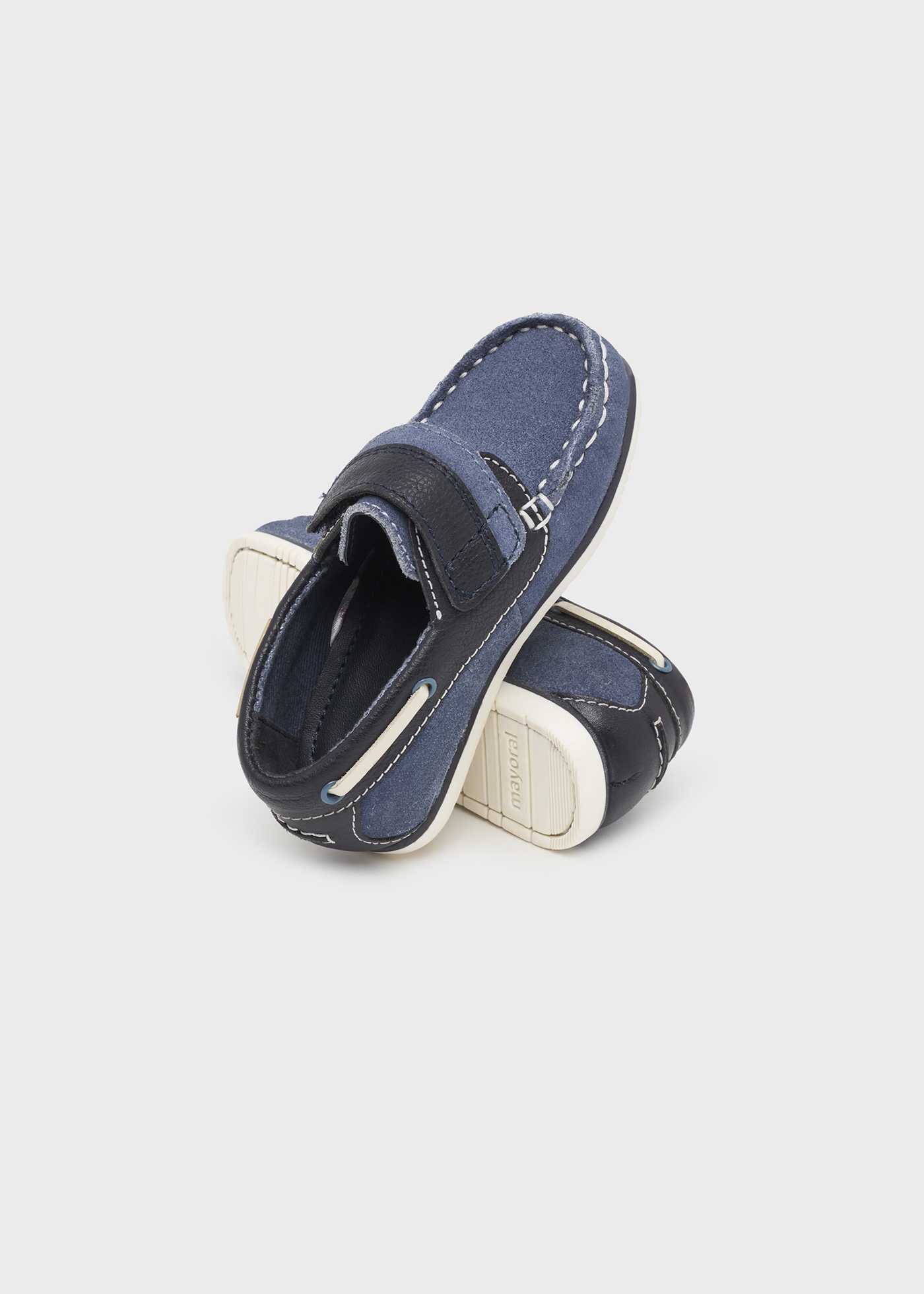 Sapato náutico infantil de couro com cordão decorativo.