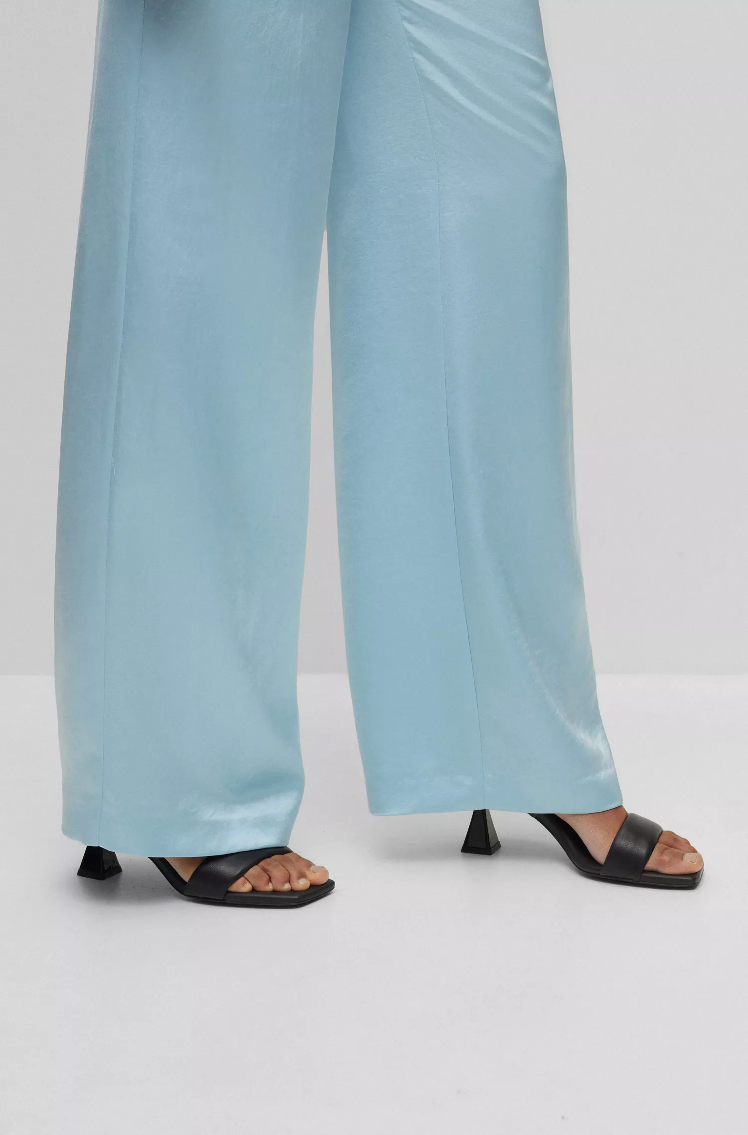 Calça flare HUGO vermelha, corte regular, em cetim, com cinto da marca.