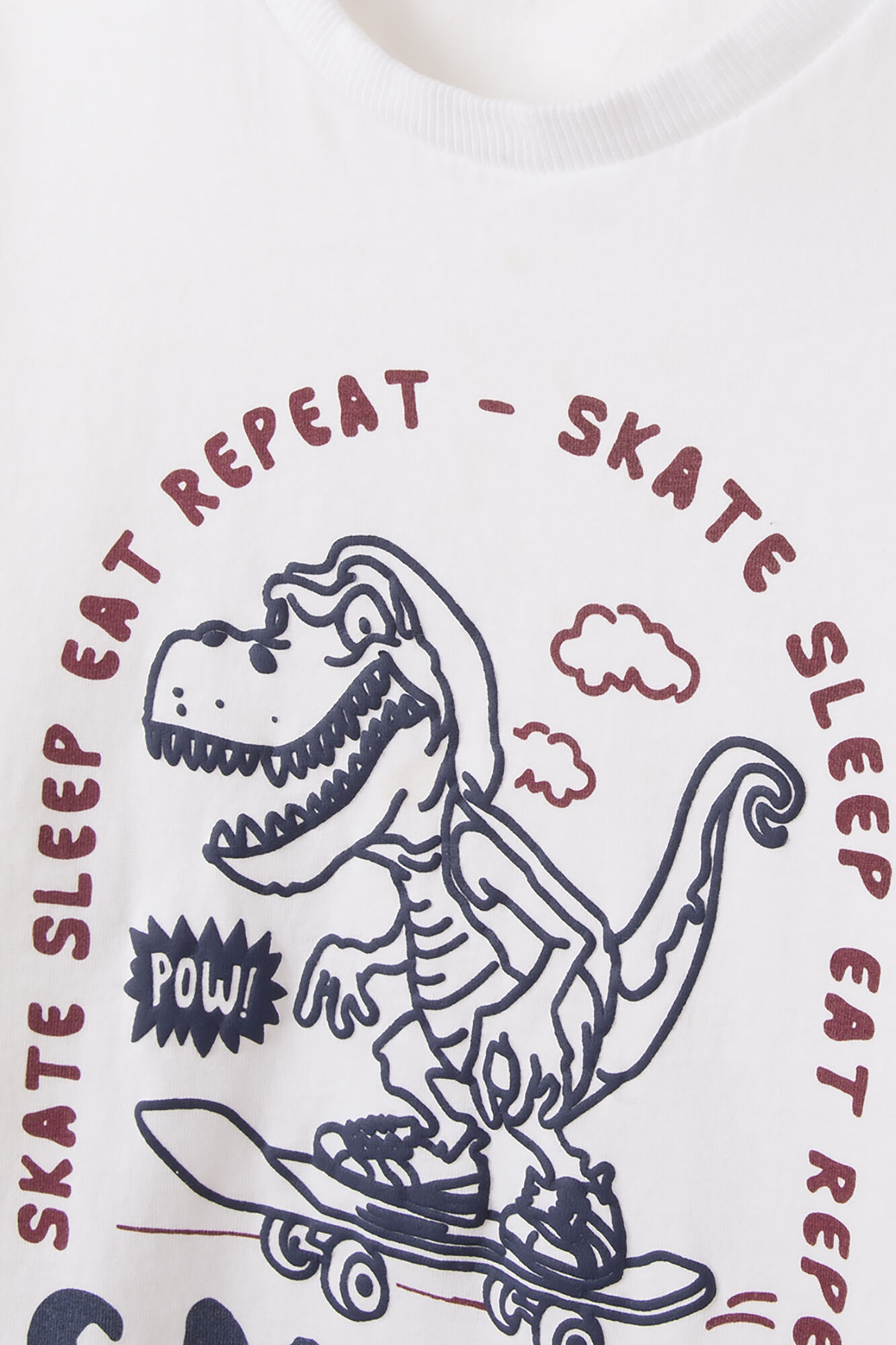 Camiseta infantil com estampa de dinossauro e skatista.