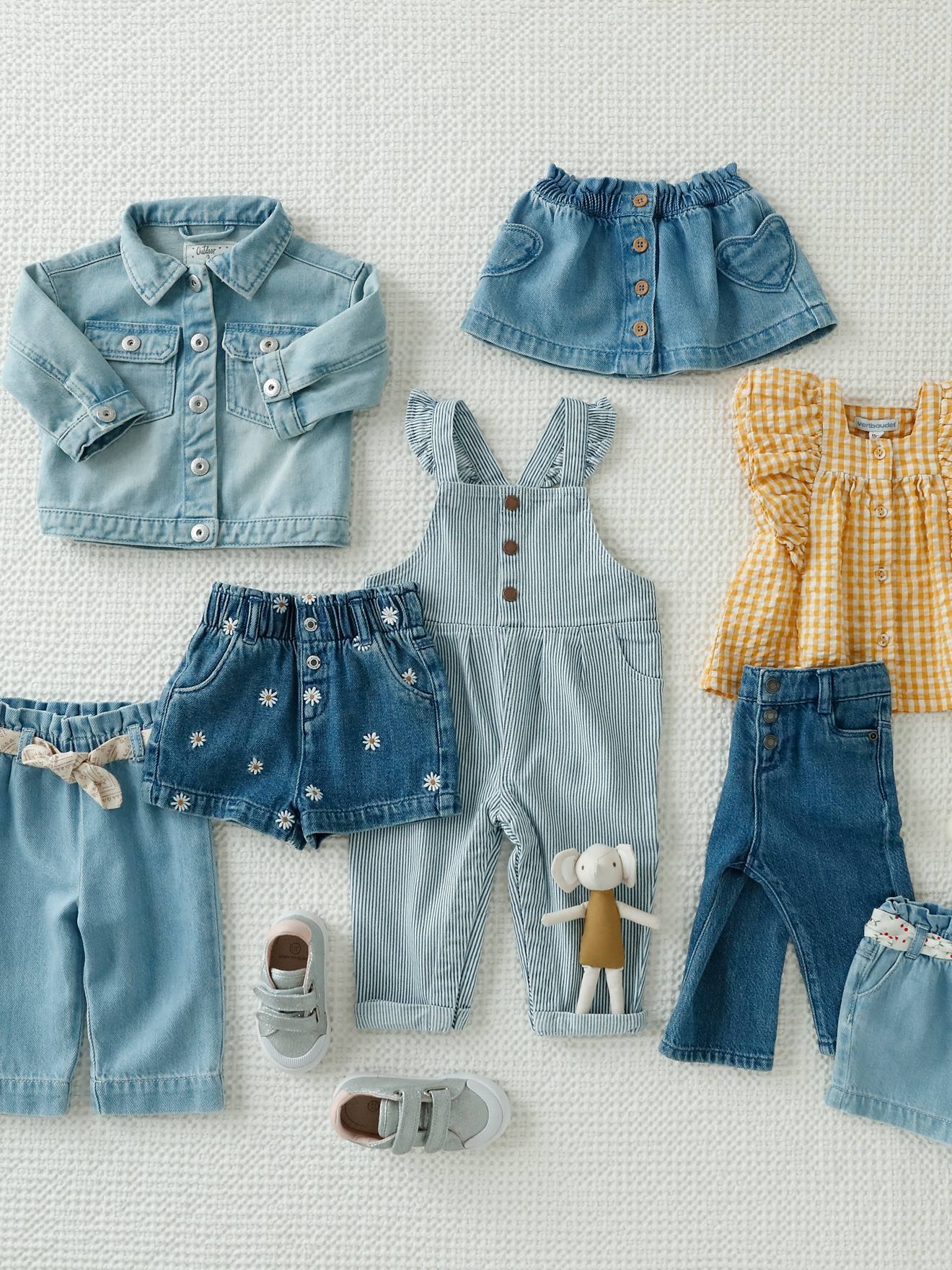 Conjunto infantil tamanho médio com blusa xadrez amarela e calça jeans de pernas largas.