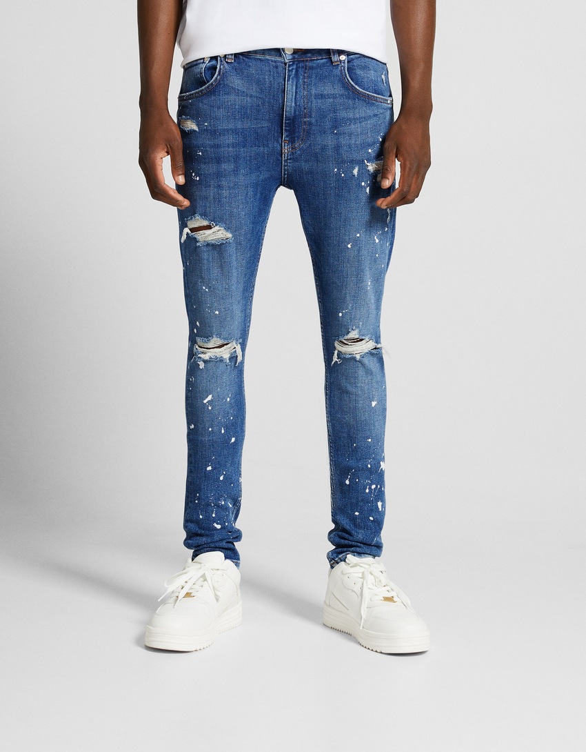 Calça jeans super skinny rasgada com respingos de tinta