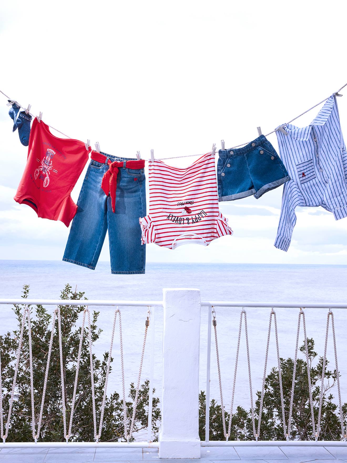 Shorts jeans azul-escuro para meninas com botões decorativos.