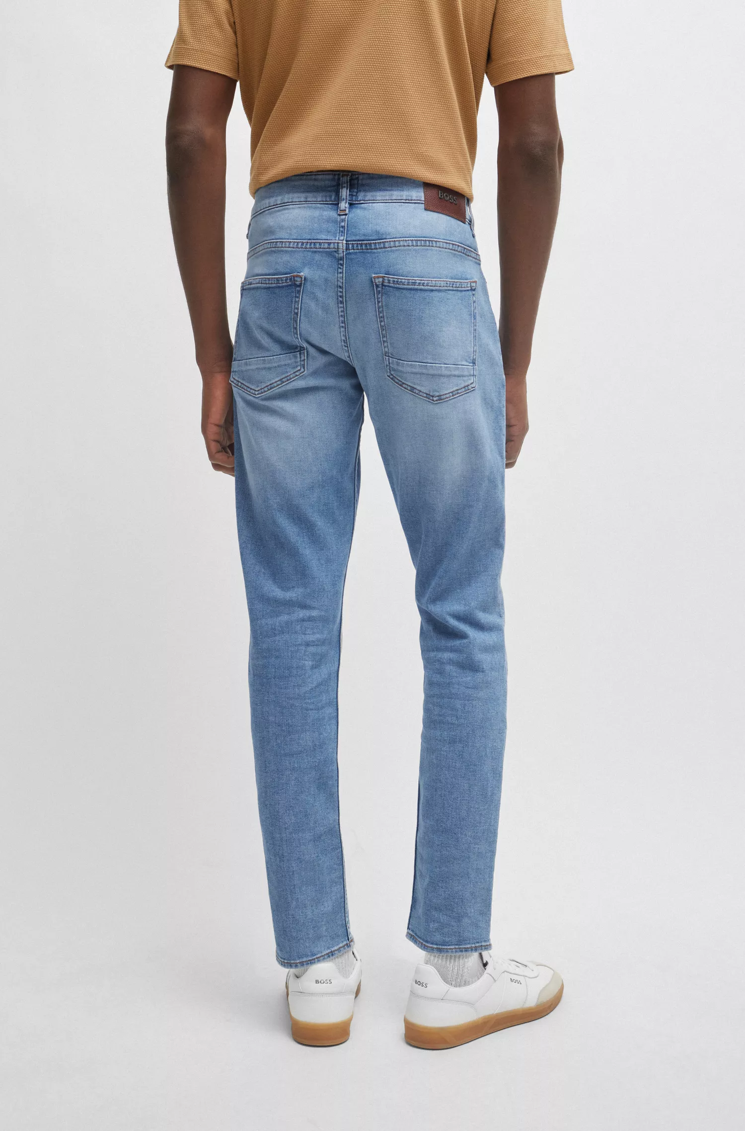 Calça jeans BOSS preta, corte slim, em denim elástico supermacio azul.